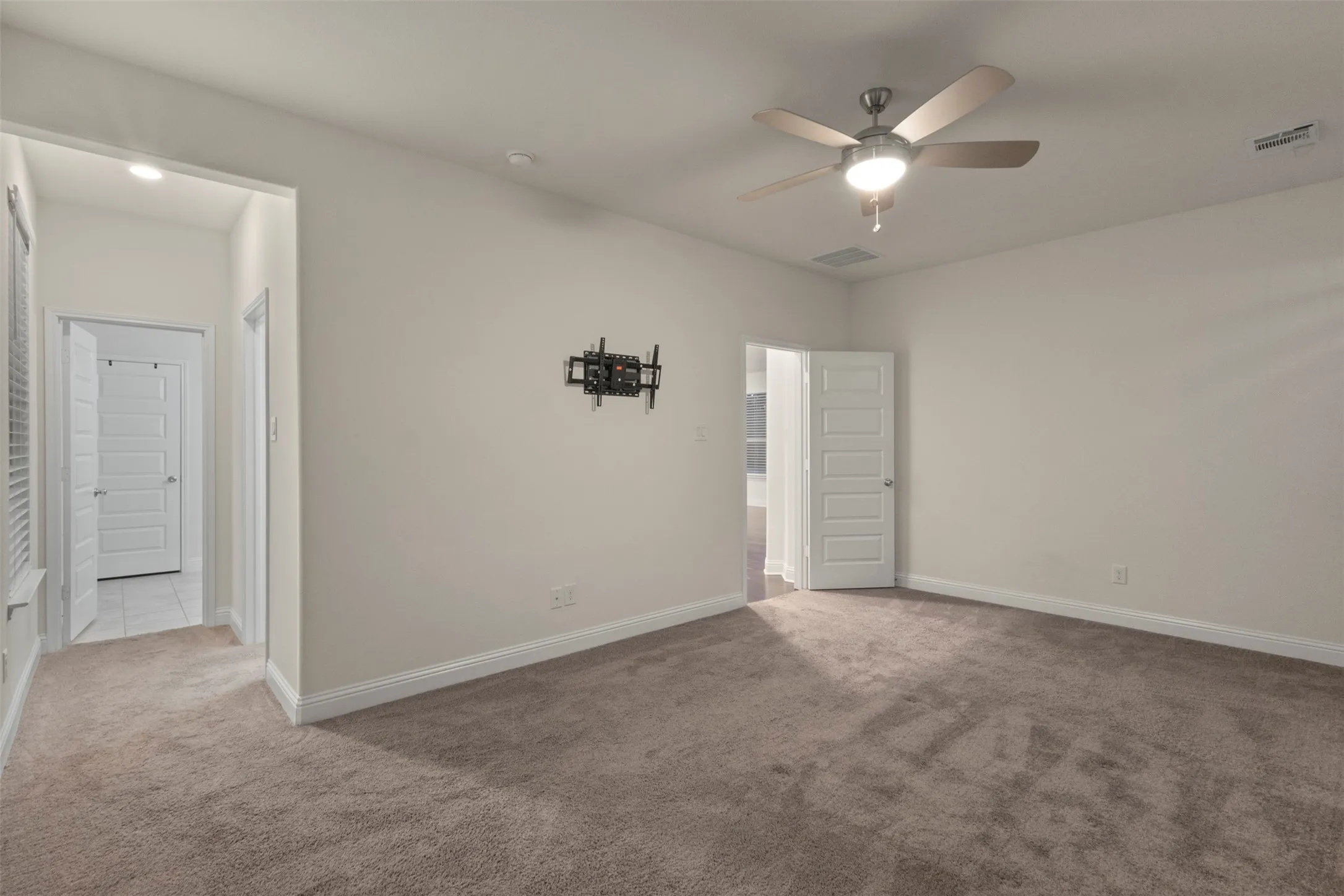 Plush carpeting, recessed lighting, and a ceiling fan with integrated light