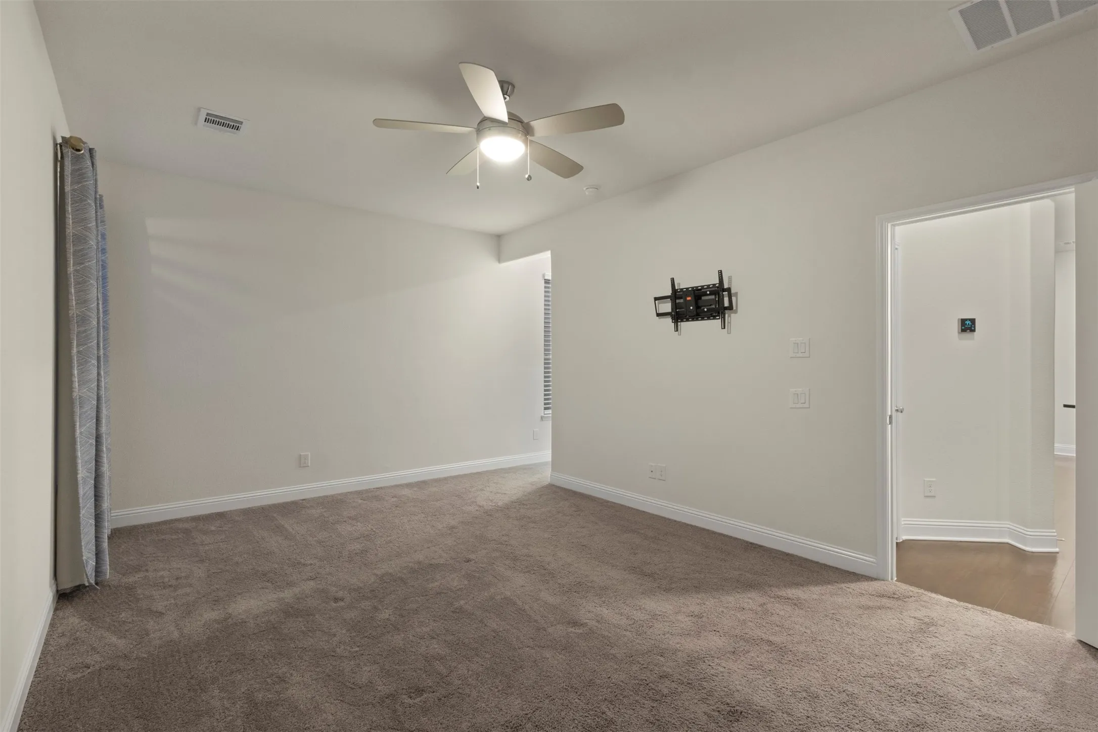 Neutral wall tones, recessed lighting, and a ceiling fan with integrated lighting