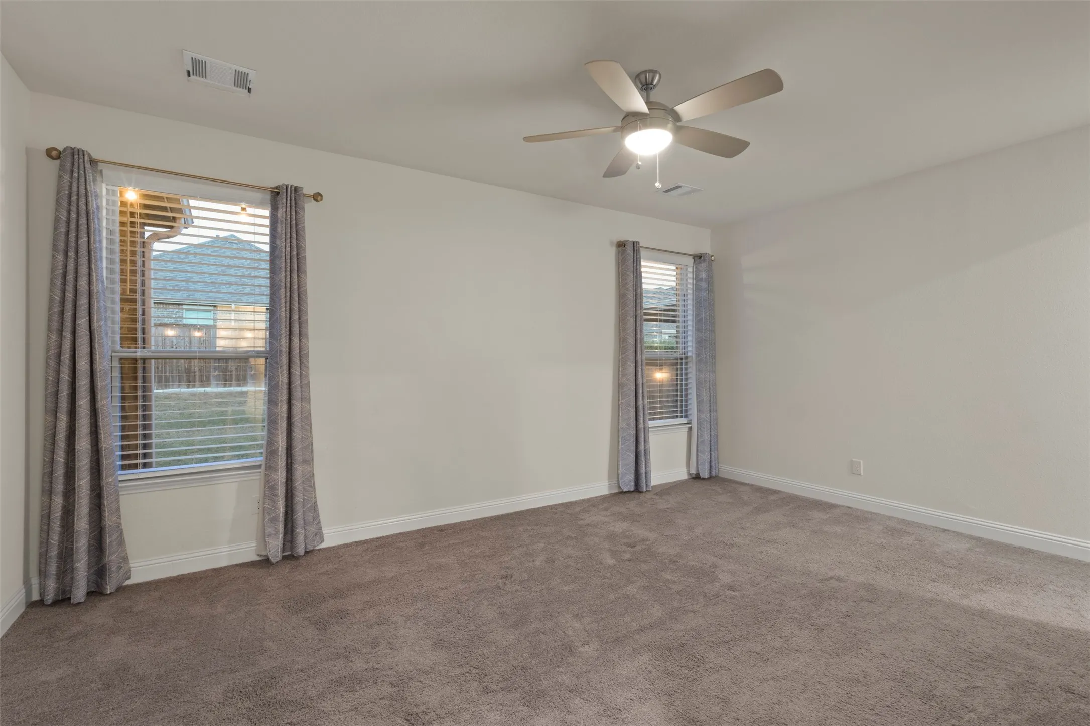 Wall-to-wall carpeting and a ceiling fan with integrated lighting