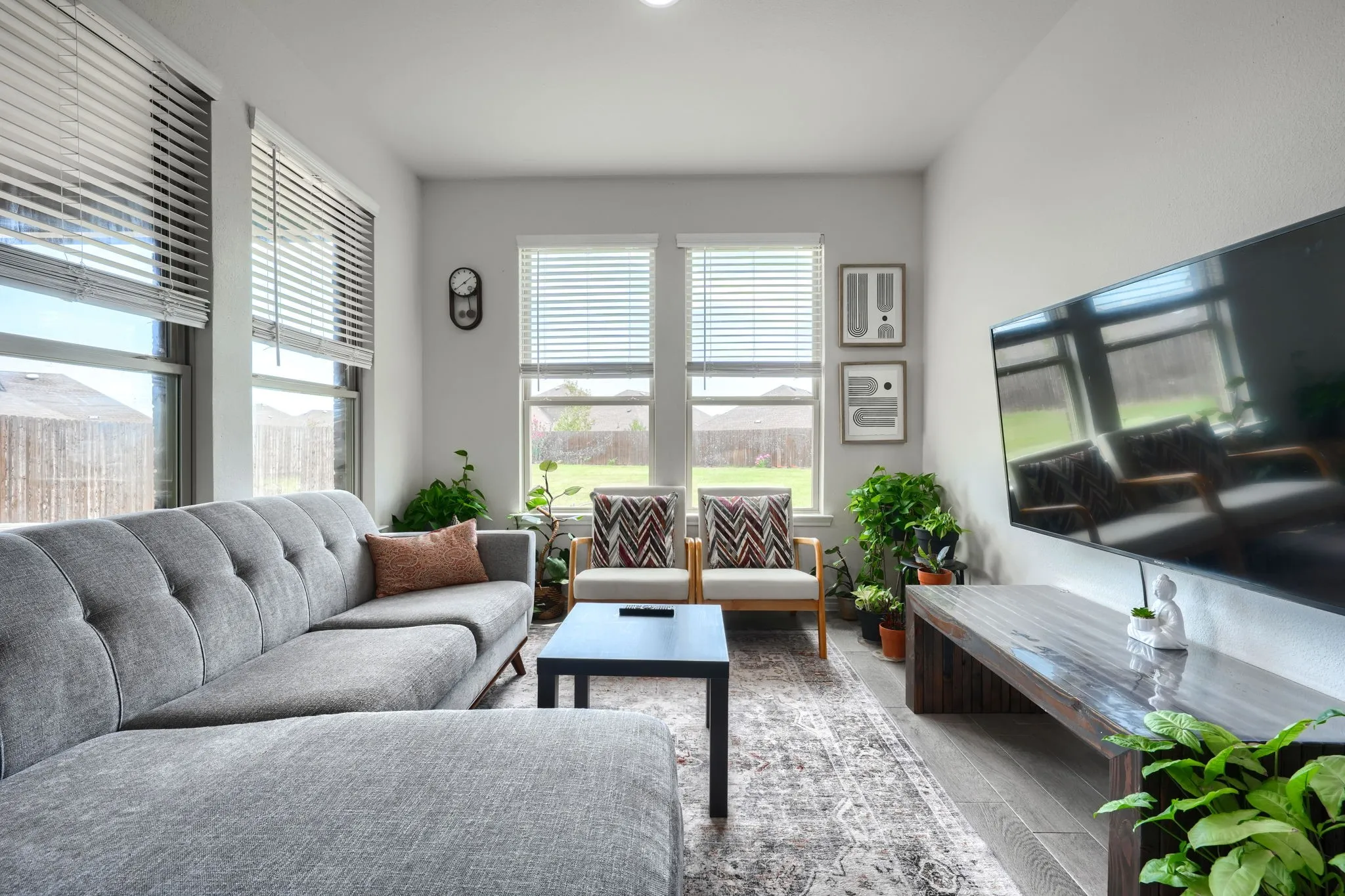 Recessed ceiling lighting, multiple large windows with blinds, light-toned wall paint, and wood-finish flooring