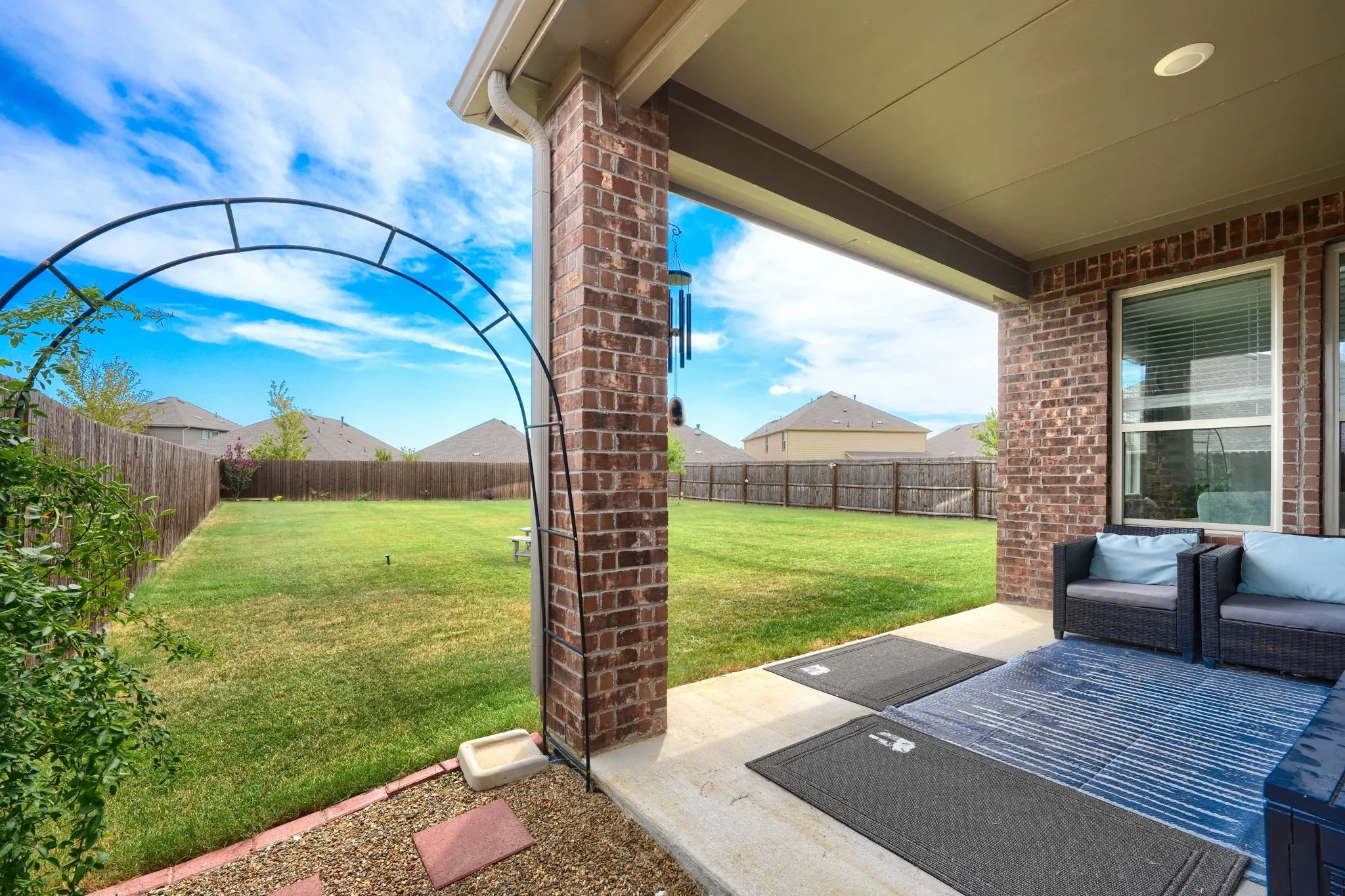 Covered patio featuring a brick pillar and concrete flooring