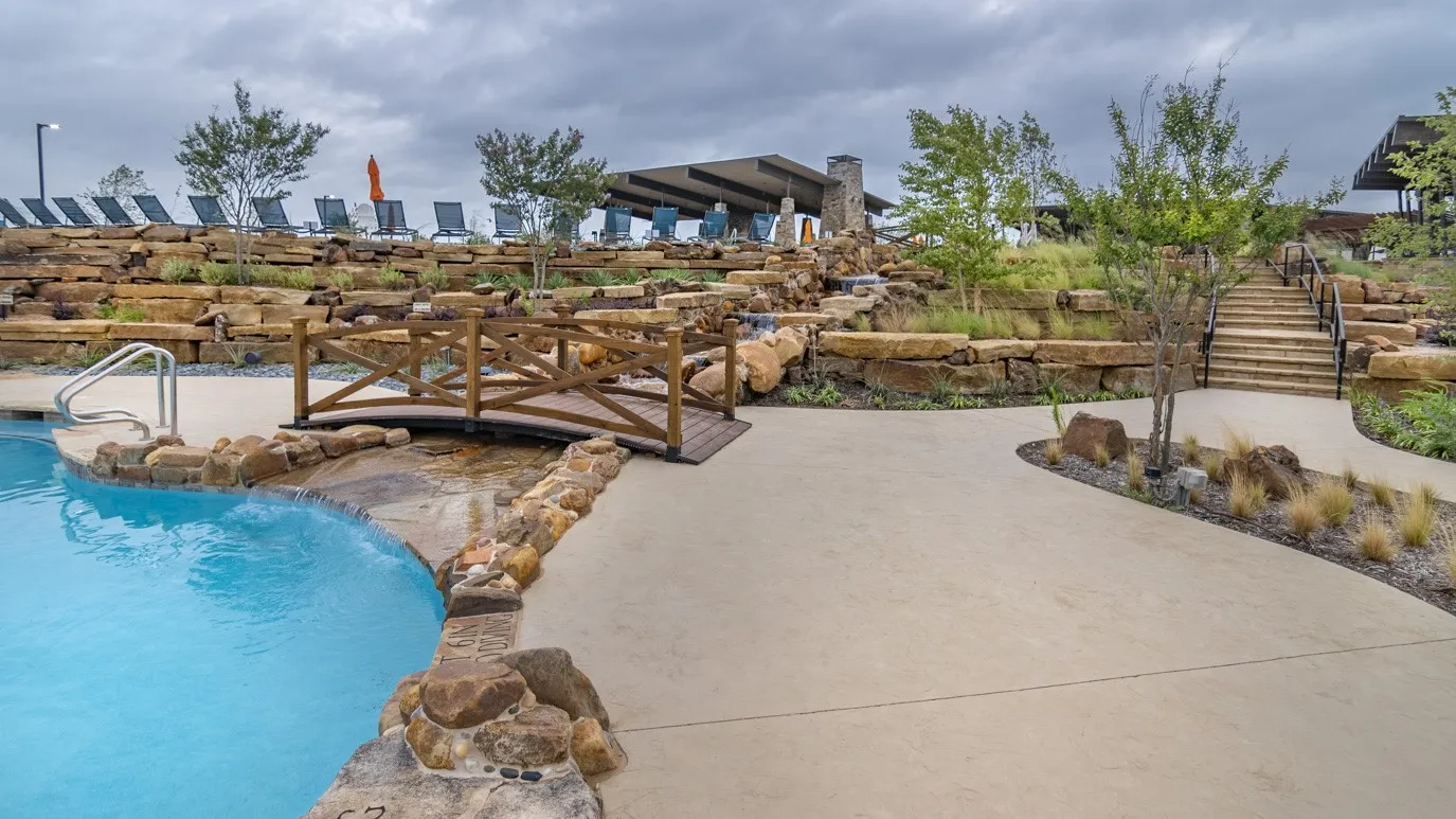 Resort-style pool with a wooden decorative bridge