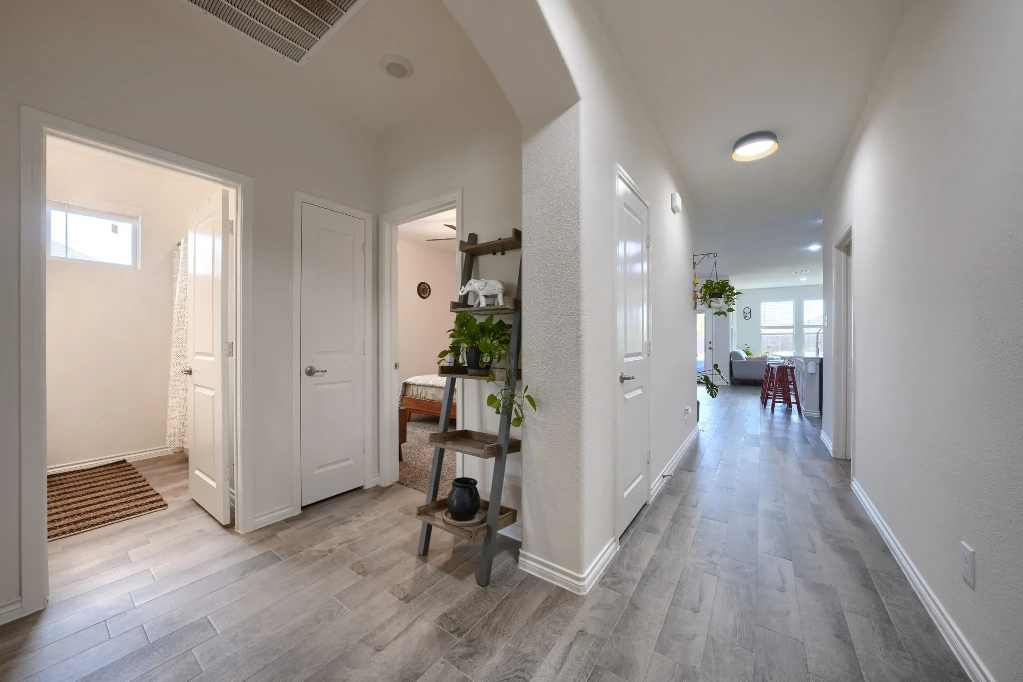 Hallway featuring wood-finish flooring, recessed lighting, and bright white walls
