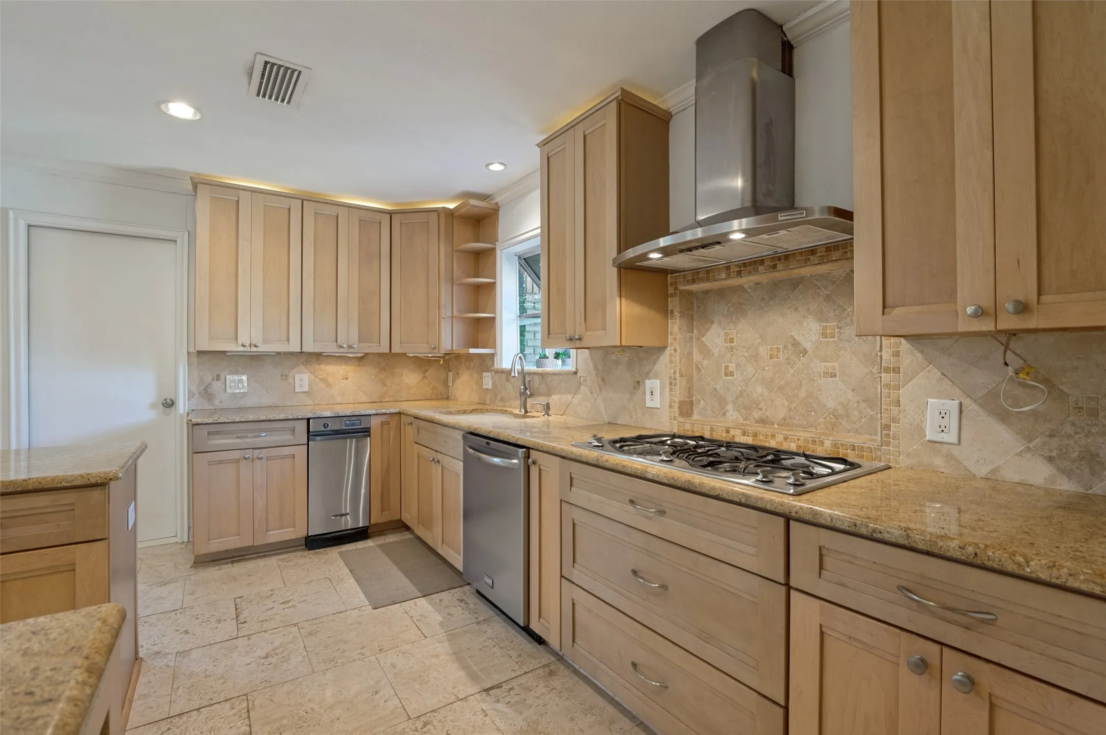 Kitchen featuring light wood cabinetry, granite countertops, tile backsplash, stainless steel appliances, and tile flooring