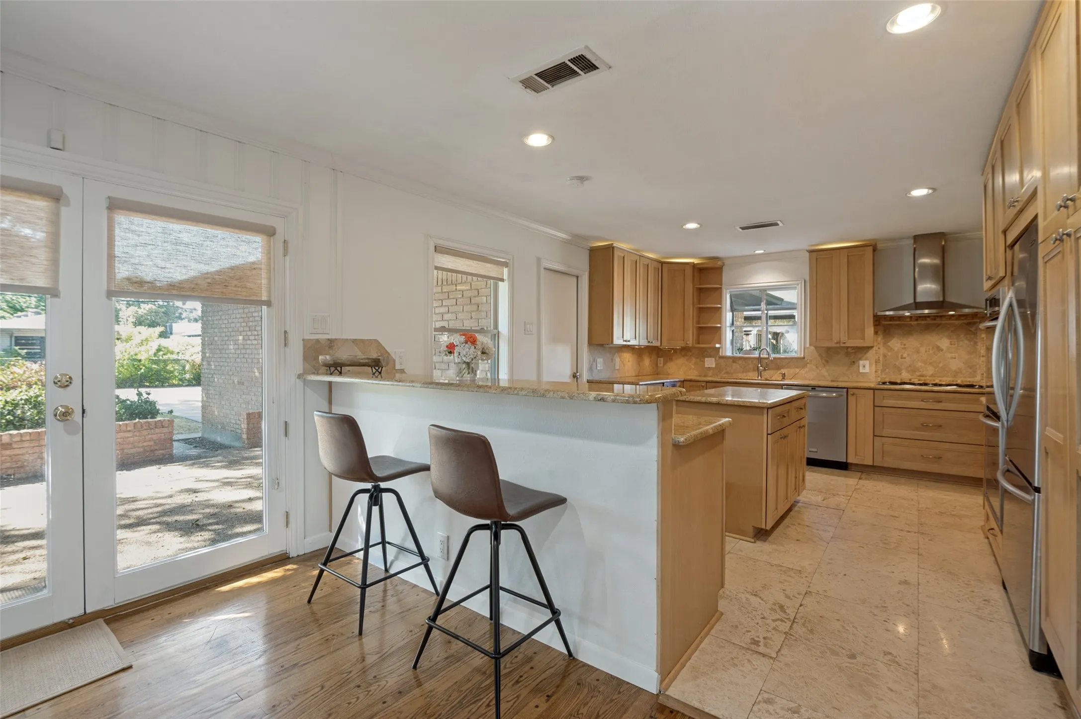 Kitchen featuring wood-finish cabinetry, stainless steel appliances, a center island, and stone countertops