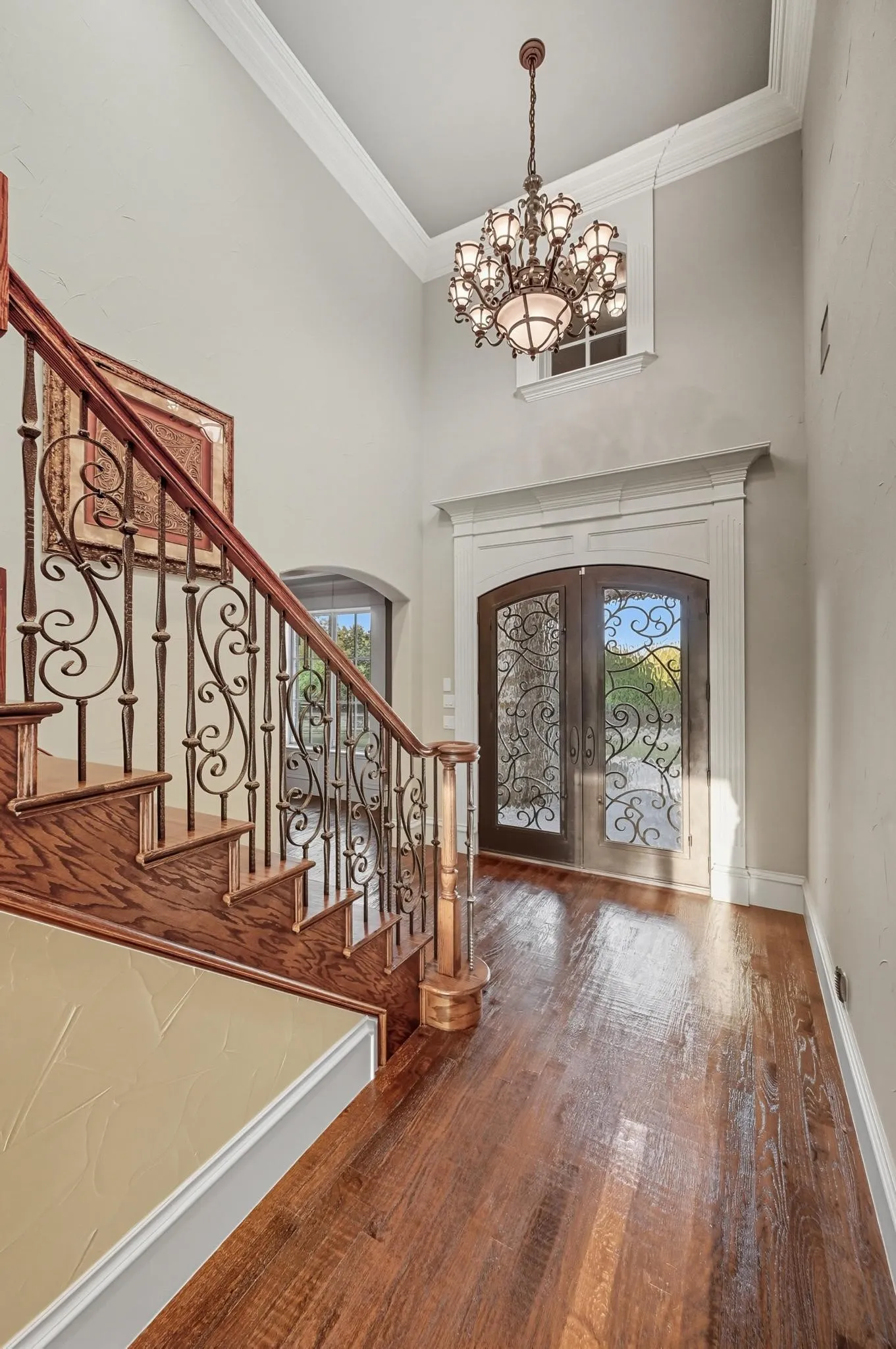The foyer welcomes you with a chandelier & flows into a living area with a wall of windows overlooking the backyard & pool.