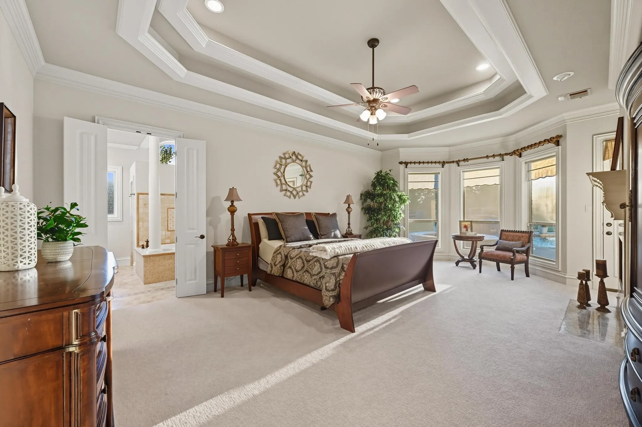 Pamper yourself in the lavish primary suite showcasing a double tray ceiling, fireplace & a massive walk-in closet with a chest of drawers, plus a spa-like bath offering a jetted tub with stylish columns, a dual-head shower & separate vanities.
