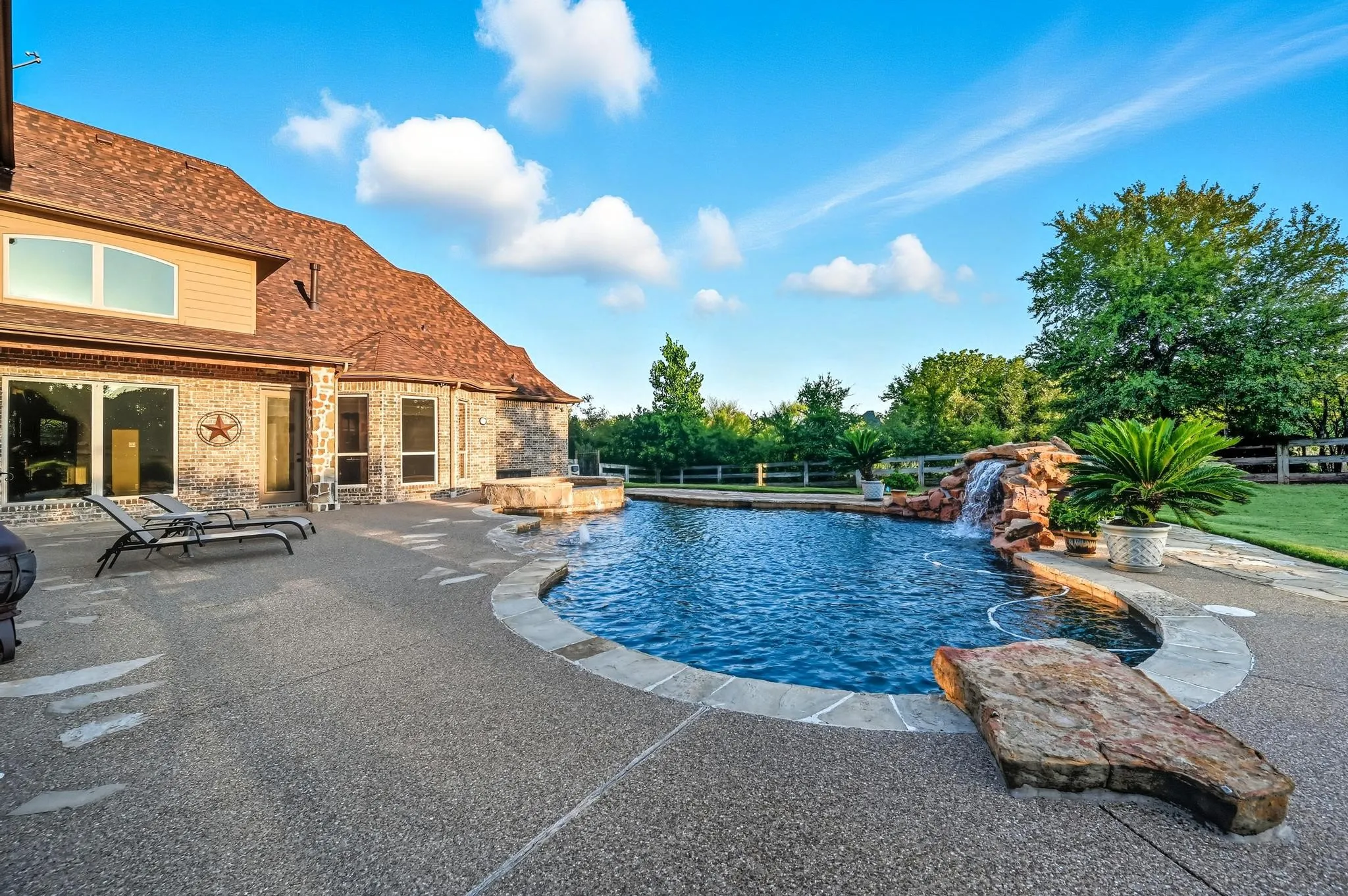 The backyard is your personal wonderland for quiet time or entertaining, boasting a large saltwater pool with a black stone bottom, an eight-foot deep end, fountain, water feature & spa.