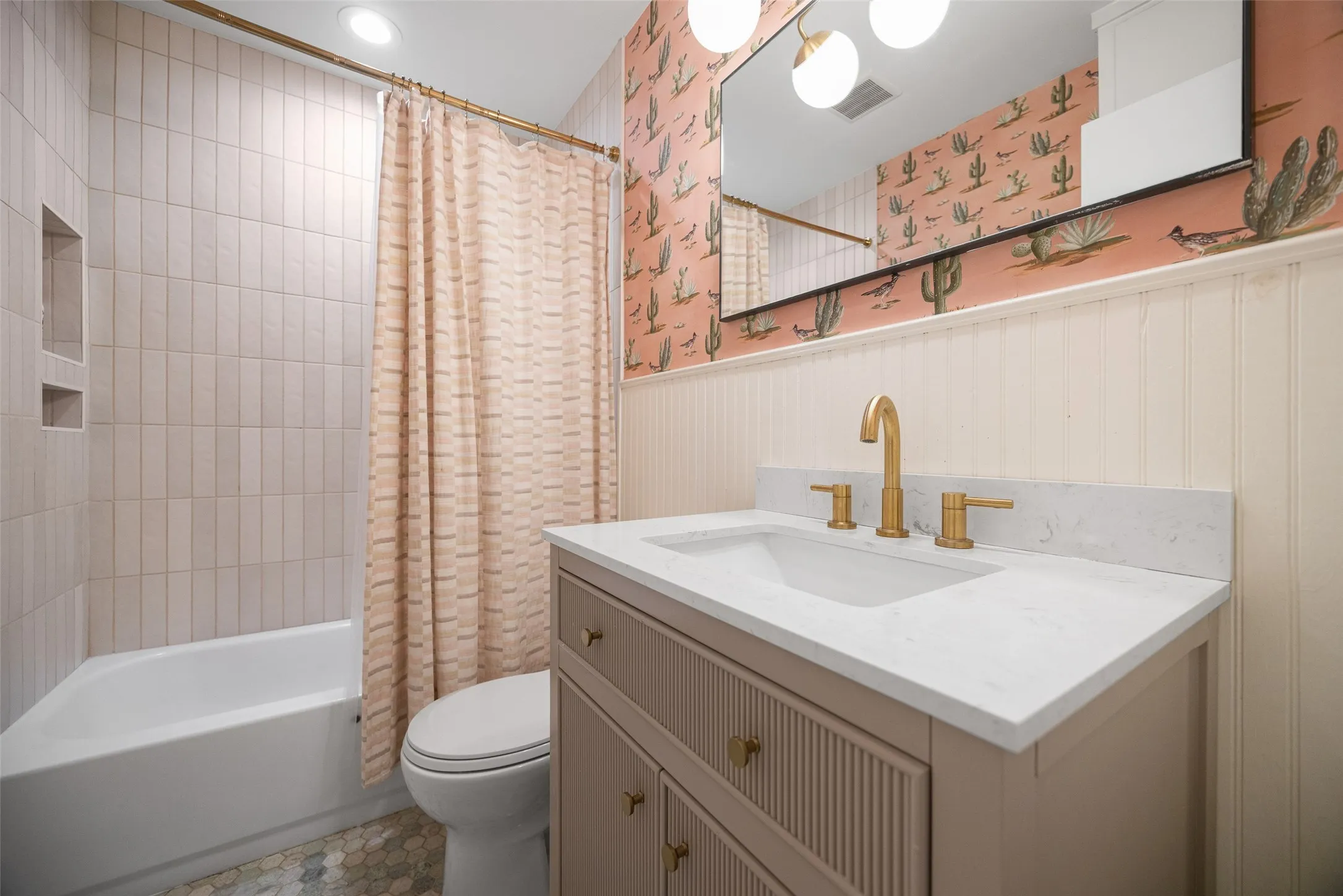 charming guest bath with designer tile and wallpaper.