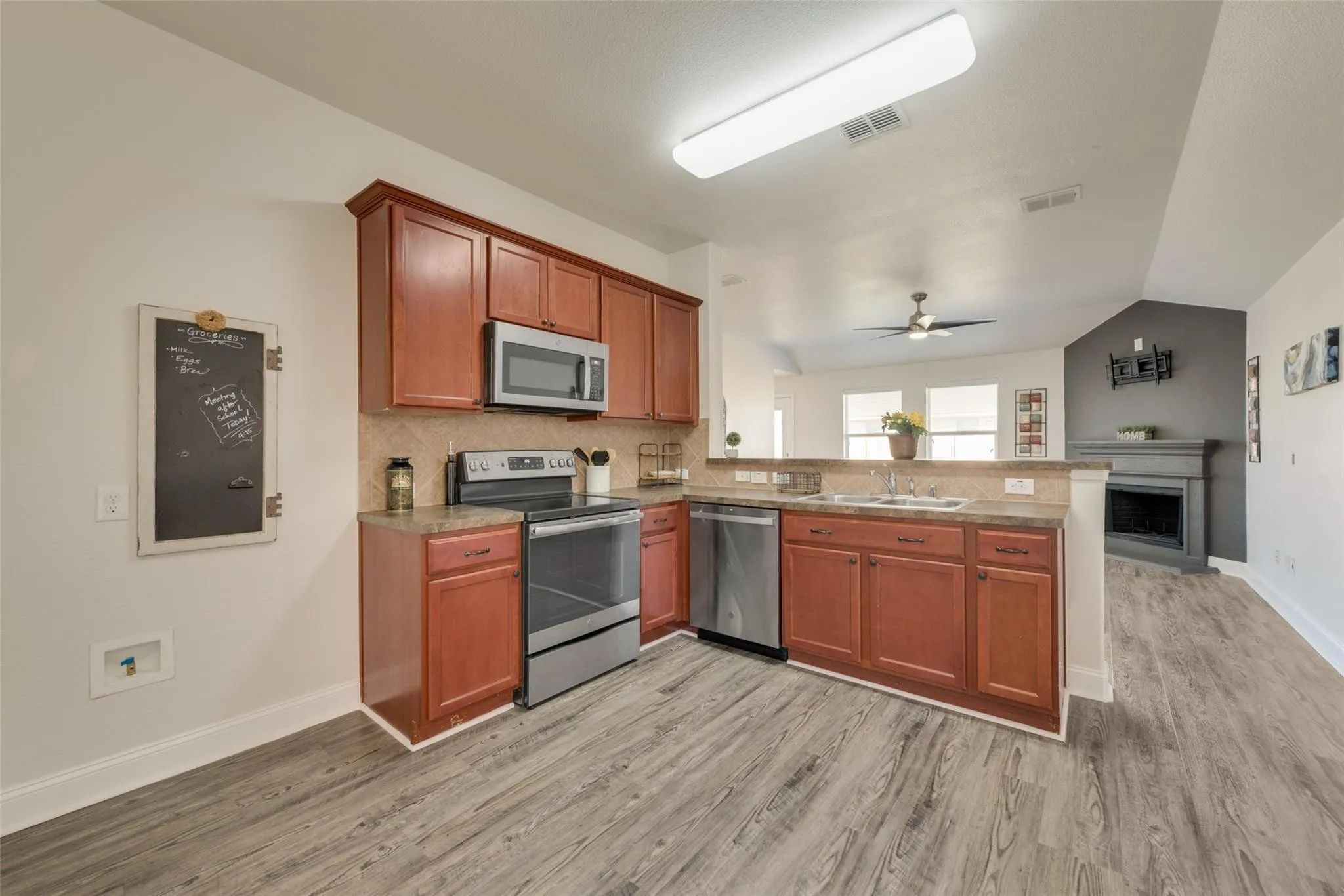 Kitchen featuring wood-finish flooring, stainless steel appliances, and wood cabinetry