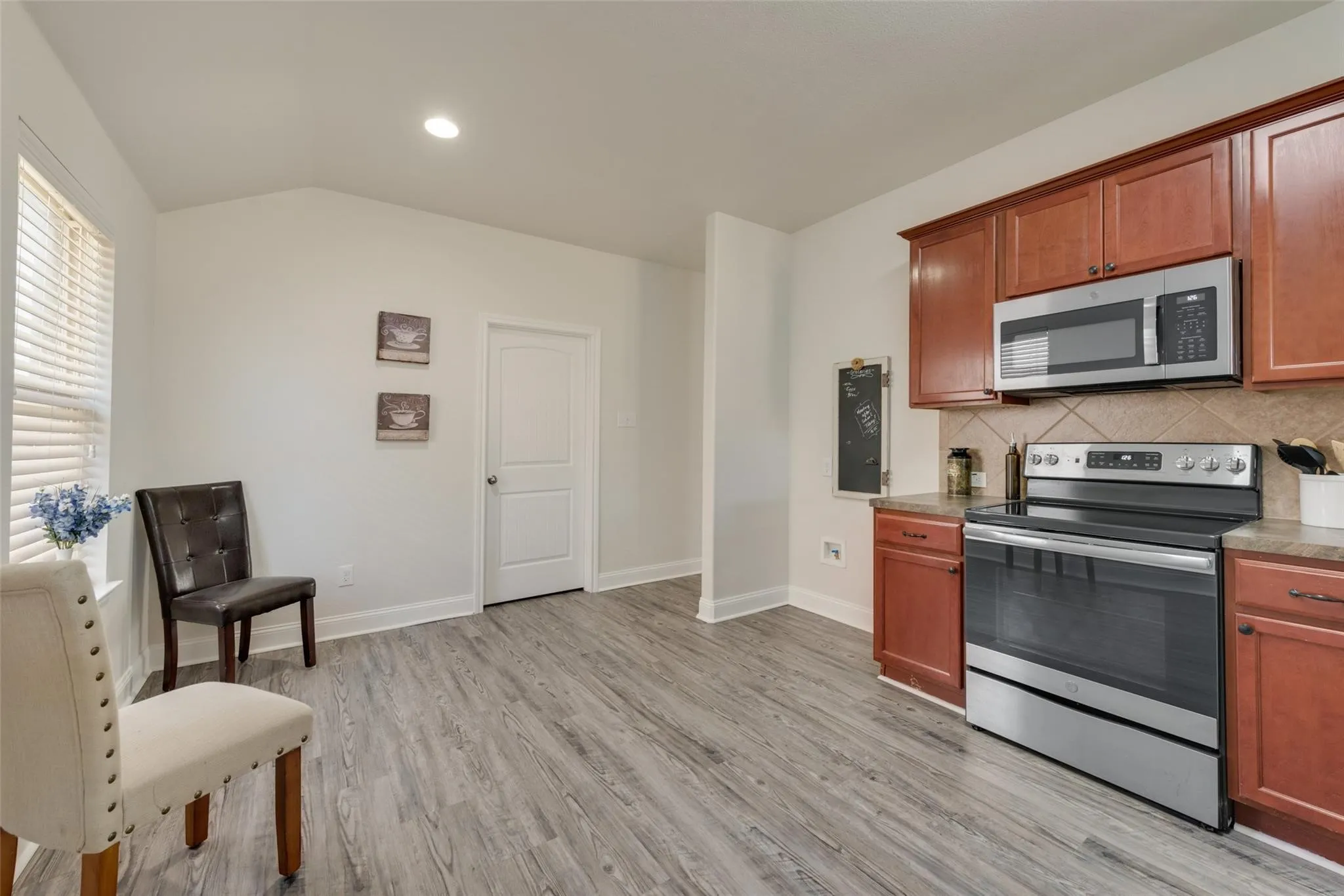 Vaulted ceiling, recessed lighting, wood-finish flooring, cherry wood-finish cabinetry, stainless steel appliances