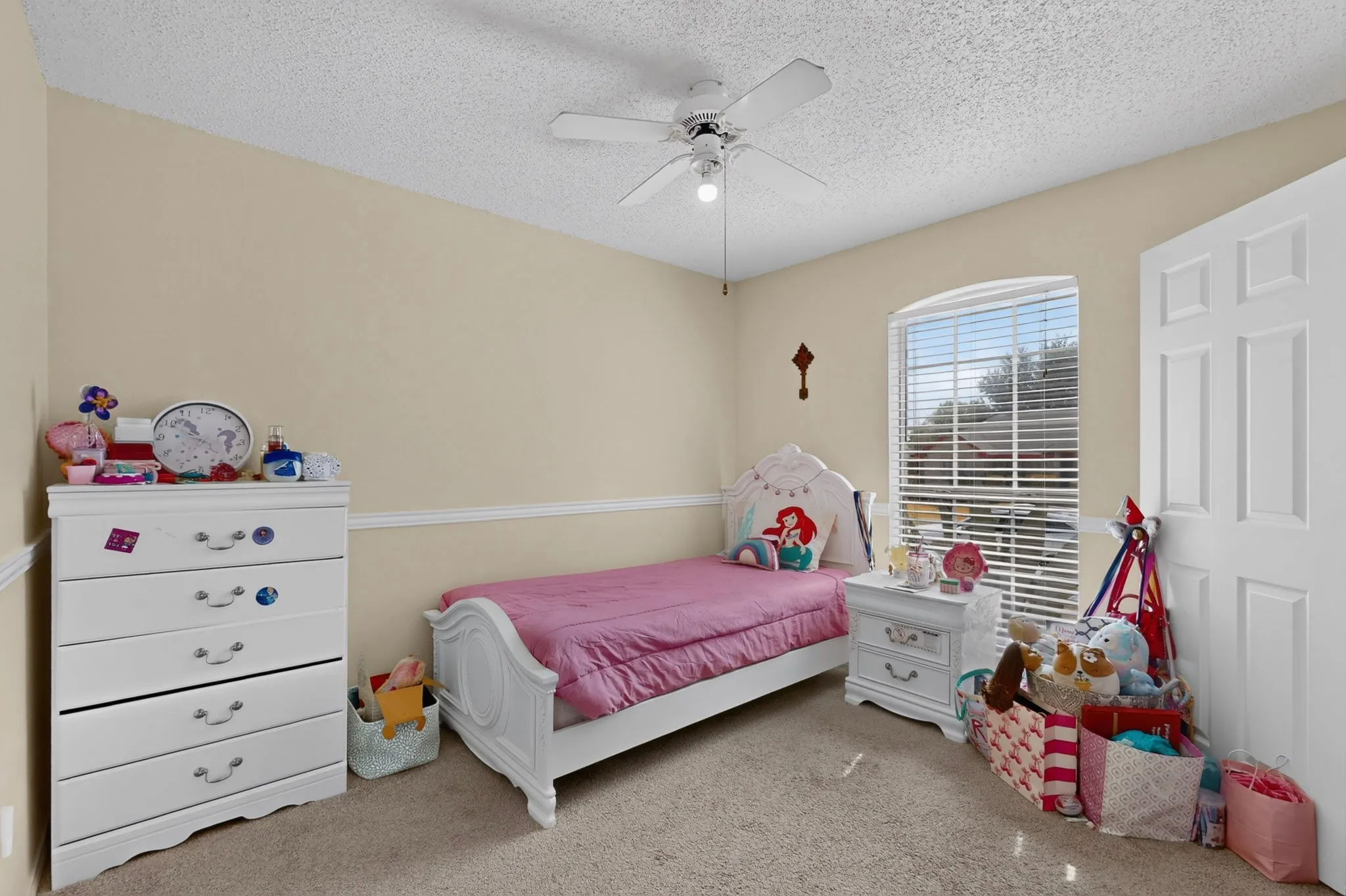 Carpeted flooring, ceiling fan with integrated lighting, window with blinds, and white paneled door