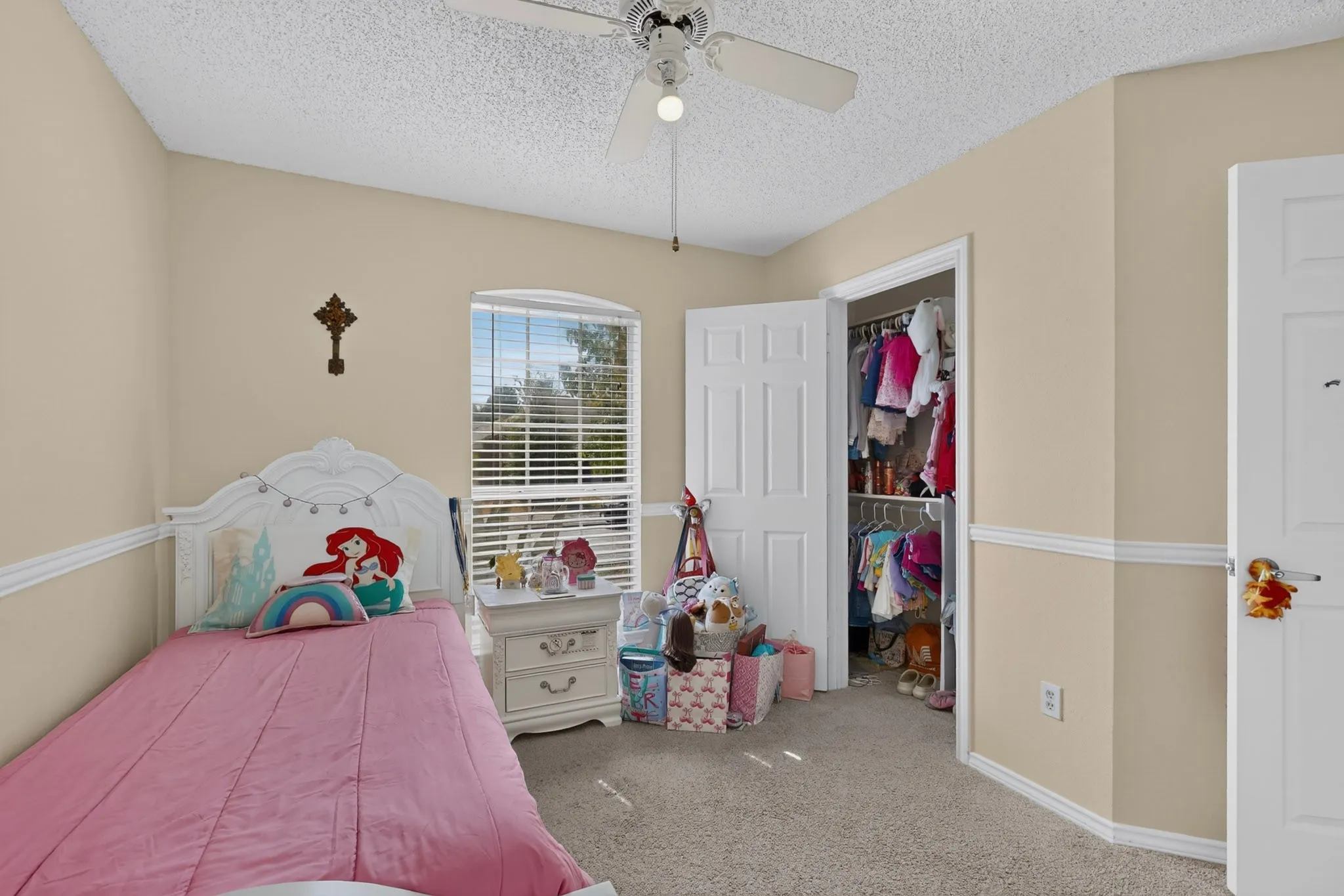 Carpeted flooring, window with blinds, ceiling fan with integrated lighting, wall trim, and a built-in closet