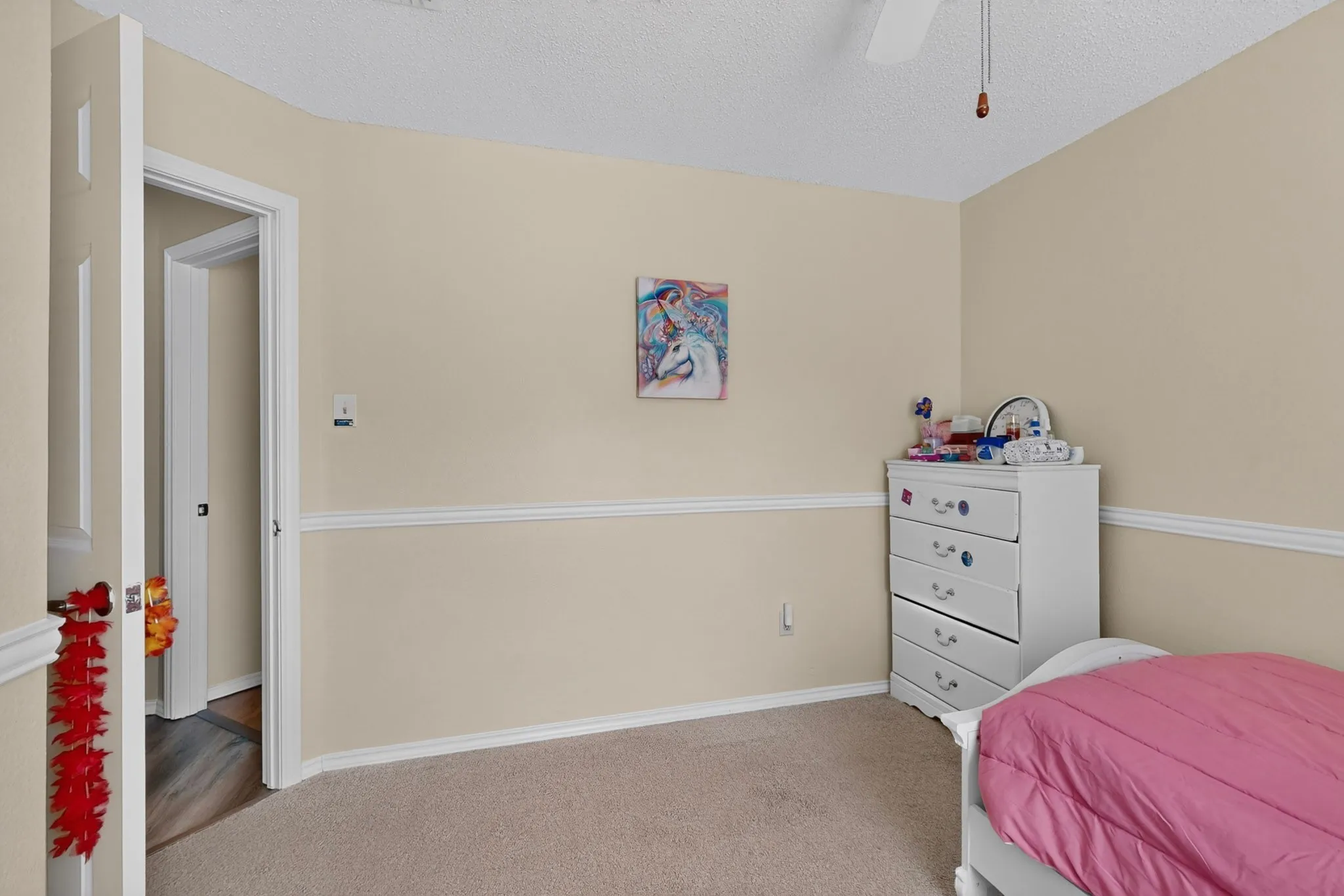 Neutral-toned walls with chair rail molding and carpeted flooring