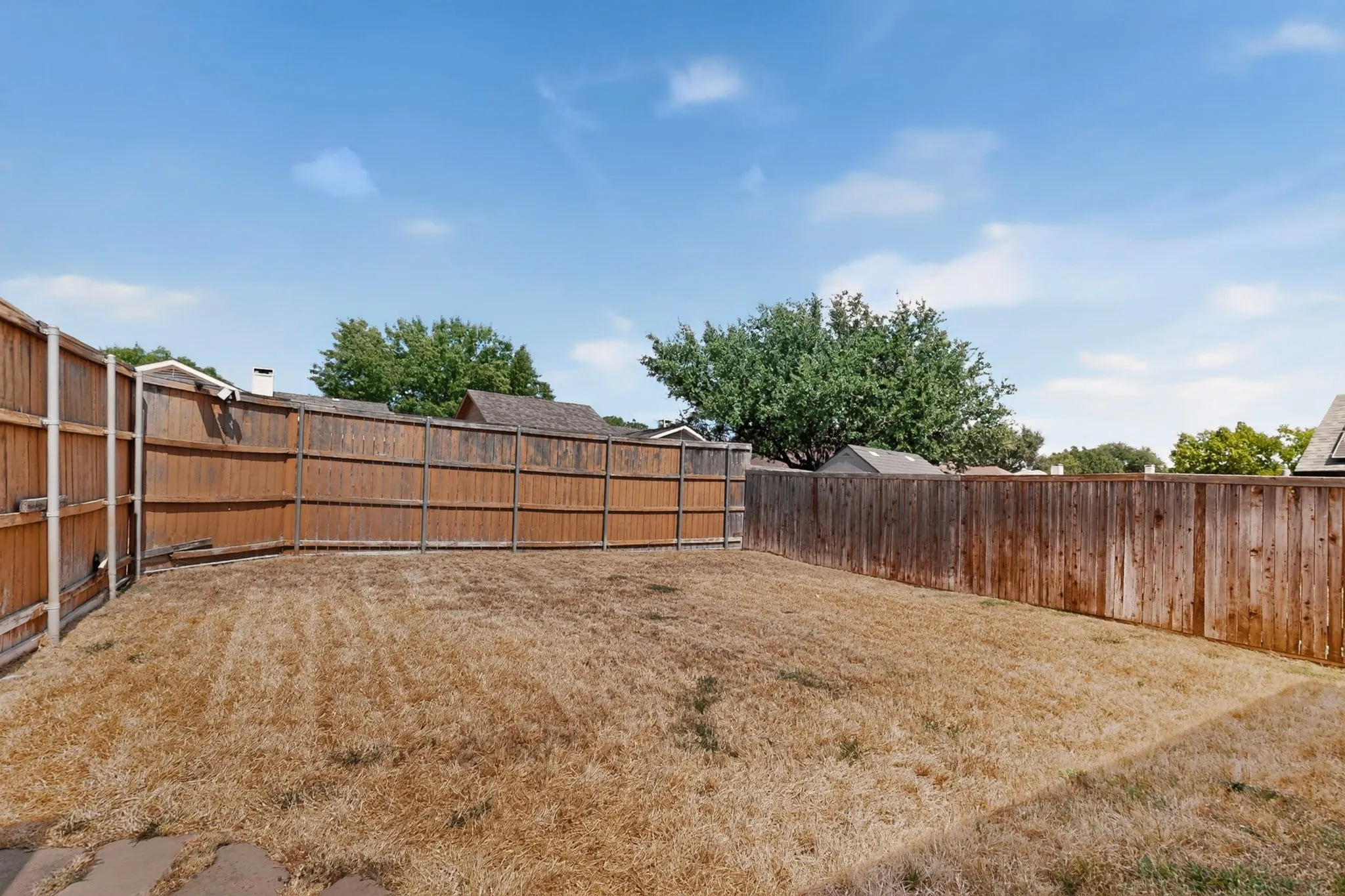 Expansive backyard space with perimeter wood fencing