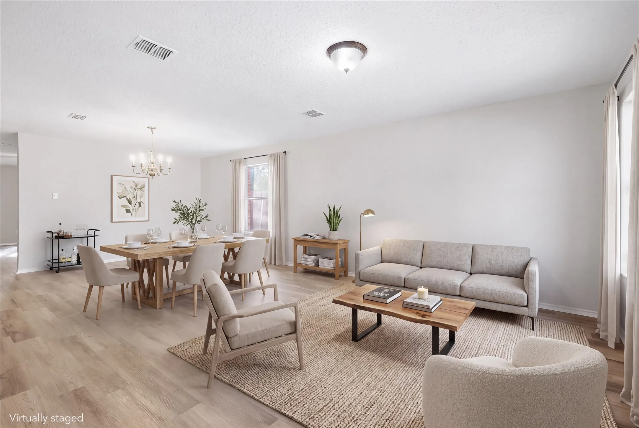 Open-concept living space featuring wood-finish flooring, recessed lighting, and a prominent window with drapes