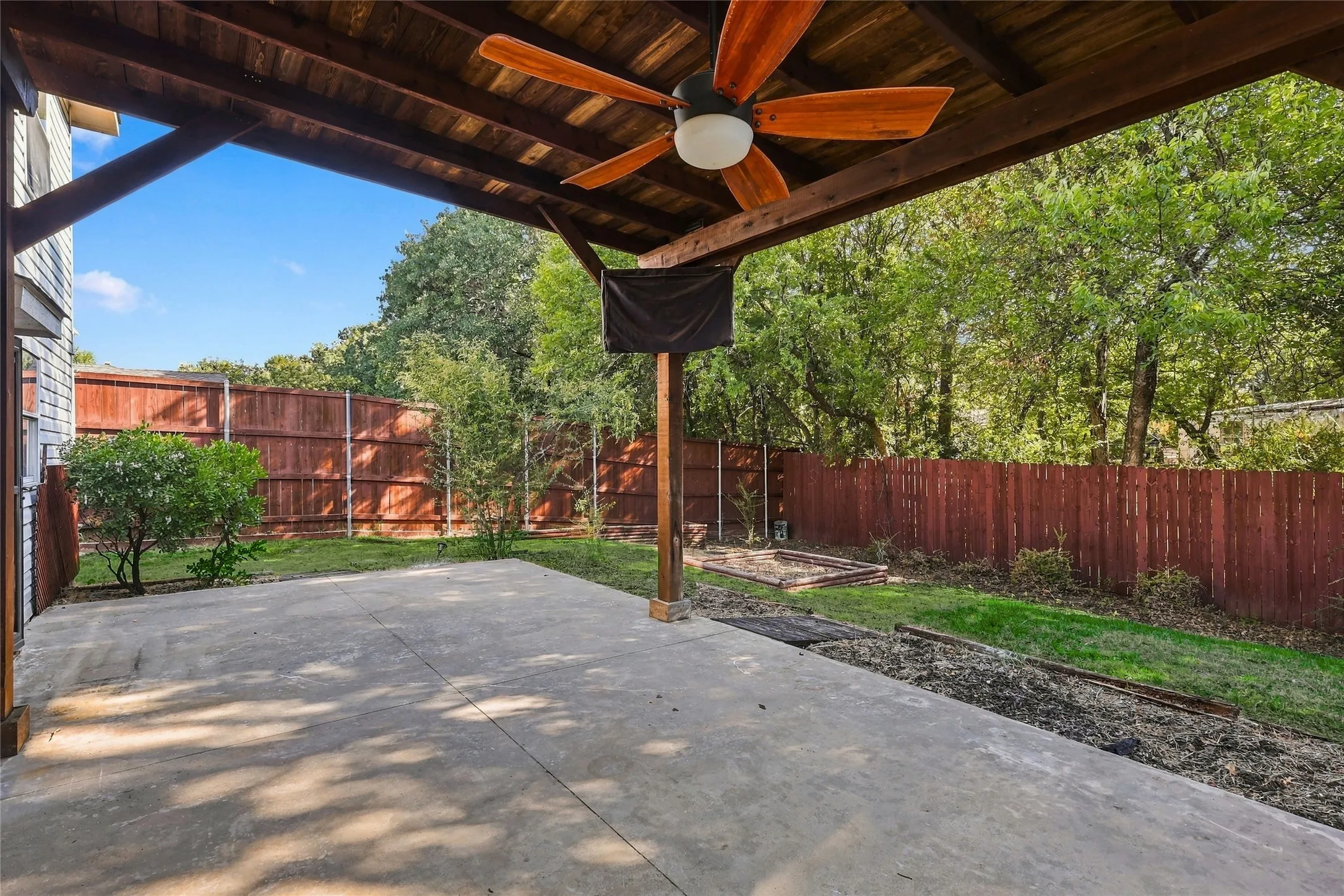 Expansive covered patio featuring a wood-panel ceiling and a ceiling fan
