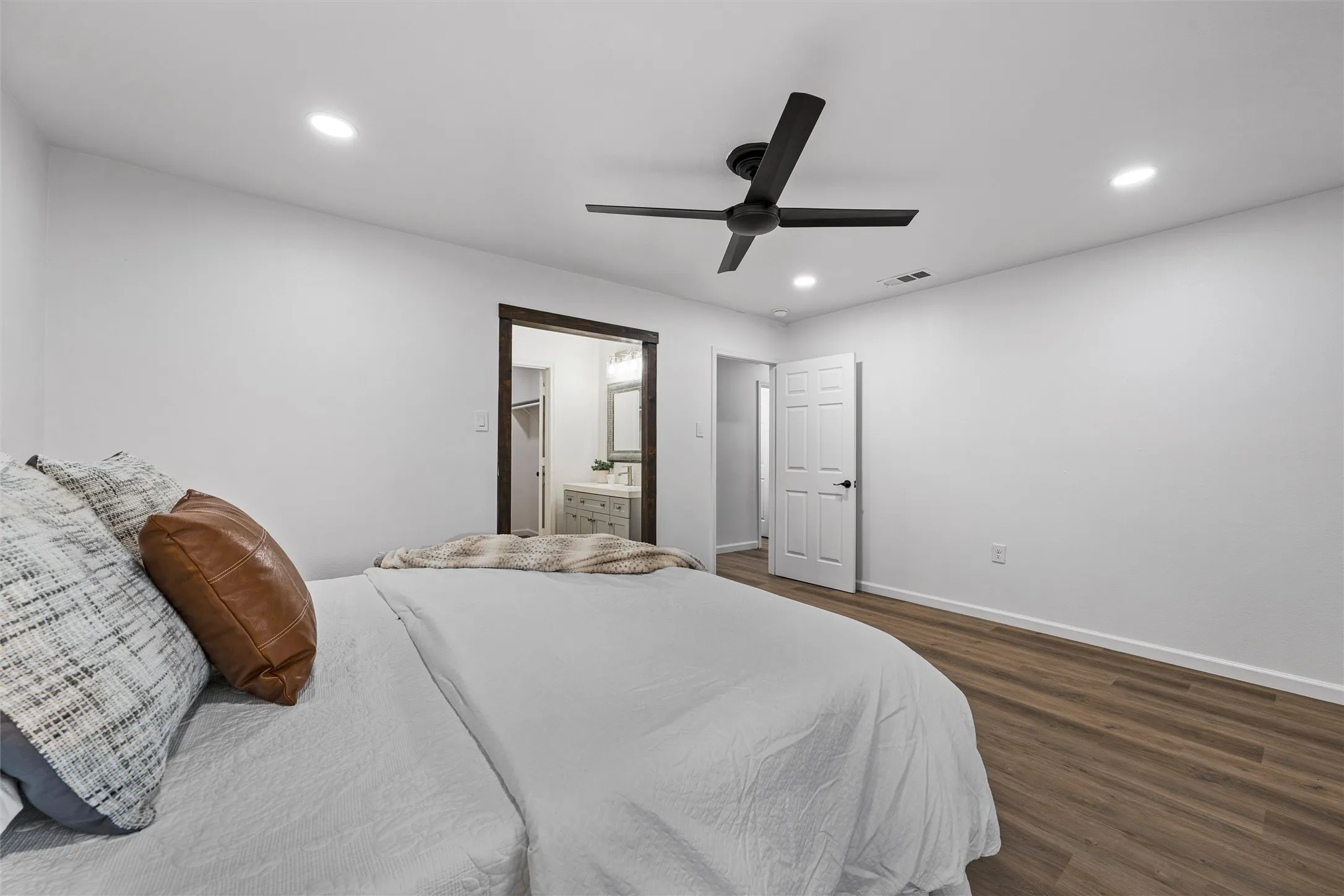 Wood-finish flooring, recessed lighting, and a dark-toned ceiling fan
