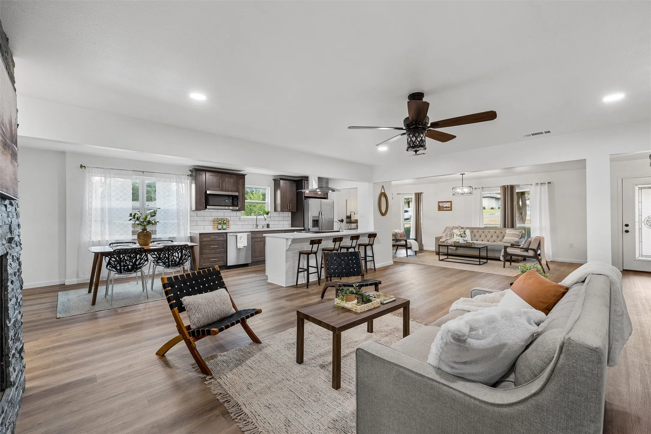 Open-concept living space featuring wood-finish flooring, recessed lighting, and a ceiling fan