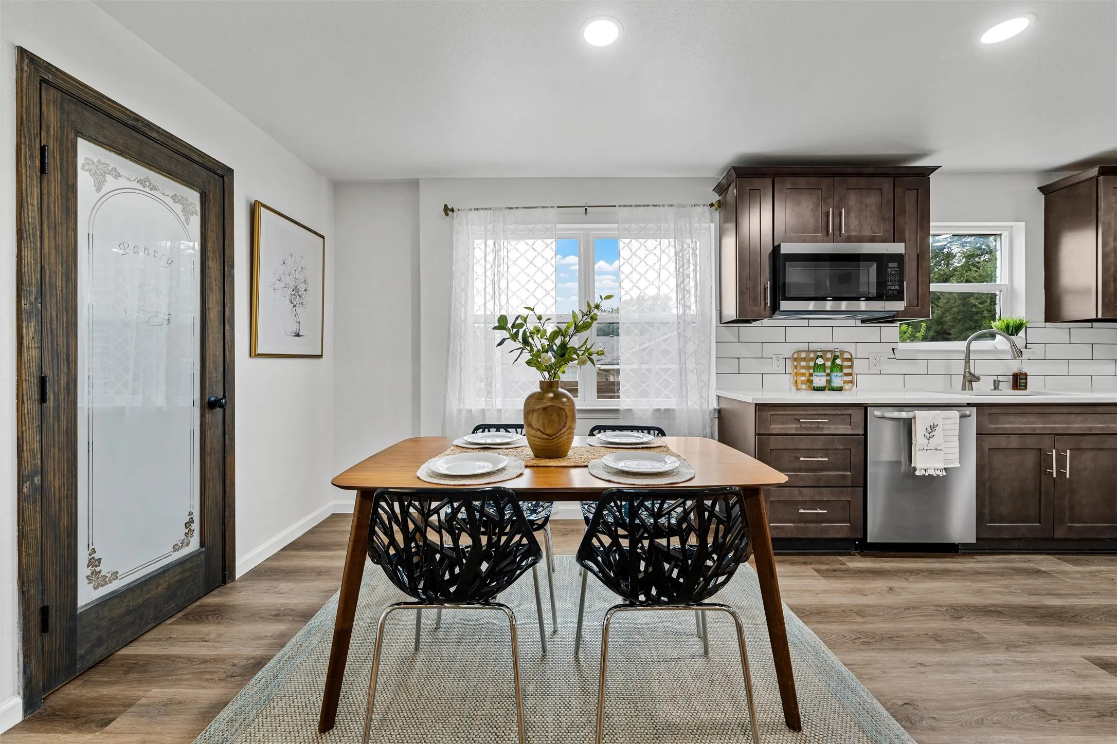 Kitchen featuring wood-finish cabinetry, stainless steel appliances, a subway tile backsplash, and light-toned countertops