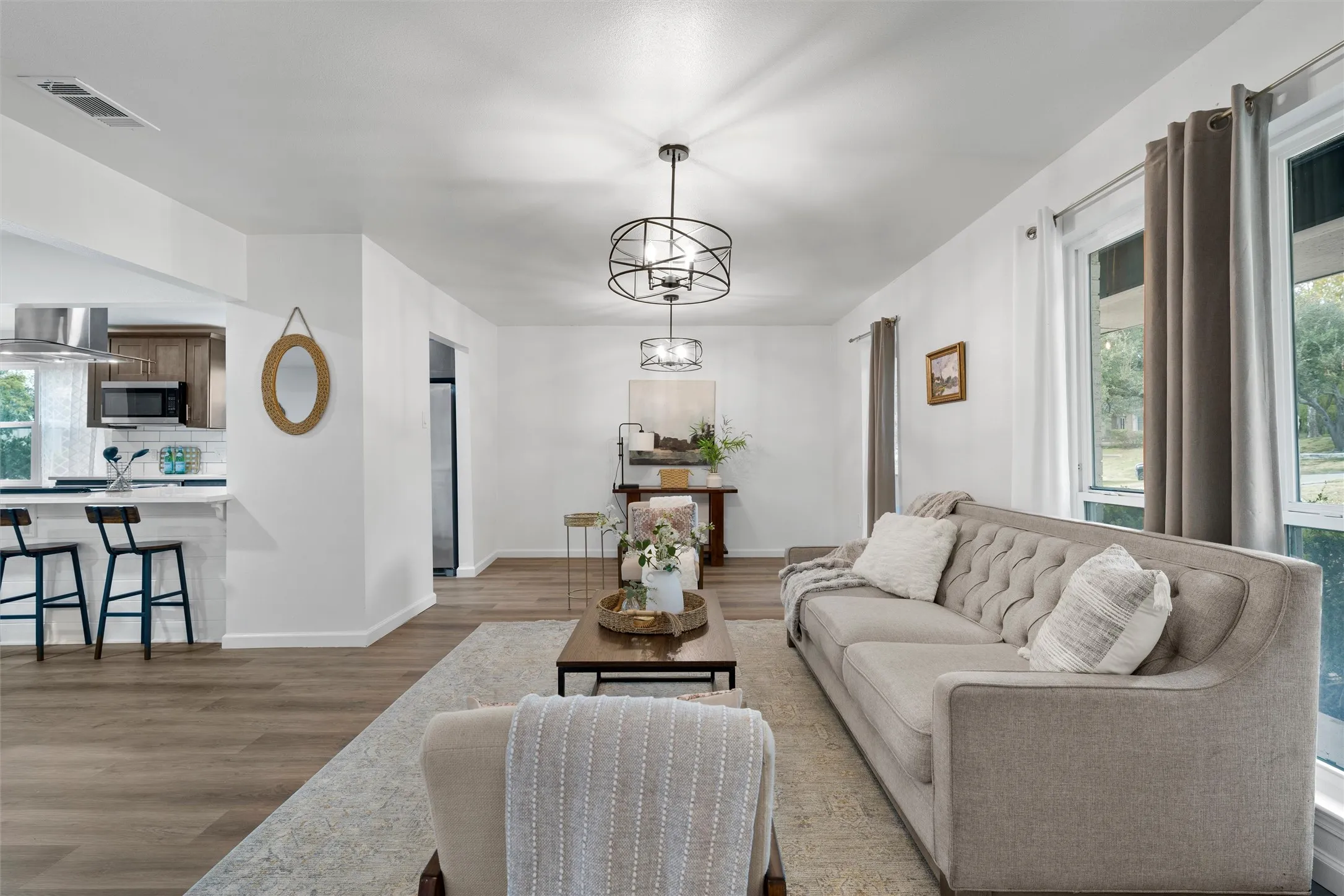 Open concept living area featuring wood-finish flooring, recessed lighting, and a modern chandelier