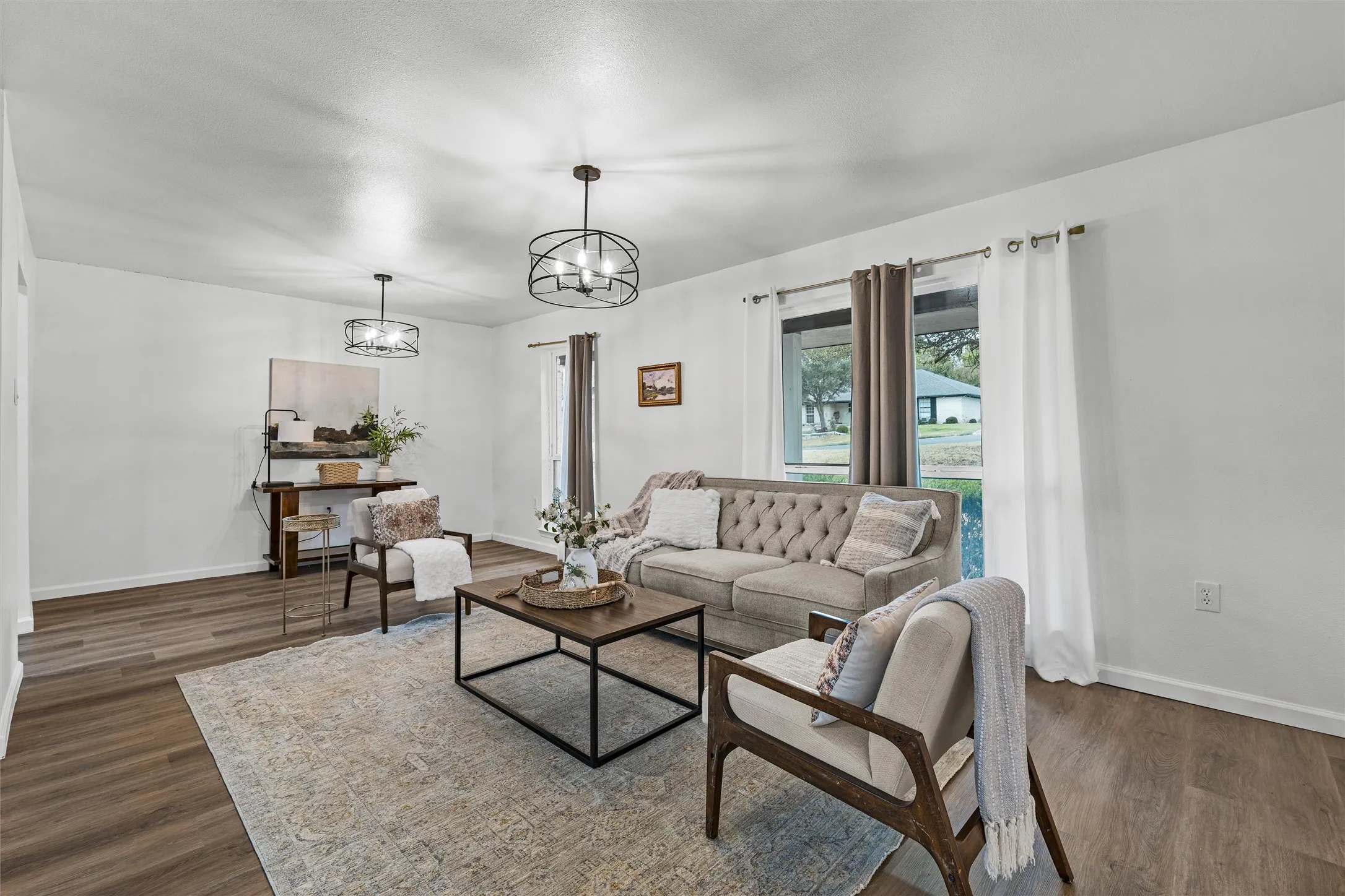 White walls, wood-finish flooring, and two windows with outdoor views