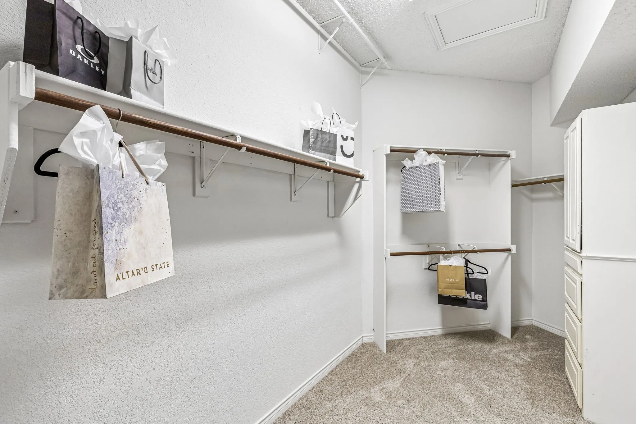 Phenomenal primary walk-in closet features a built-in dresser, tall ceilings and abundant room for seasonal storage.