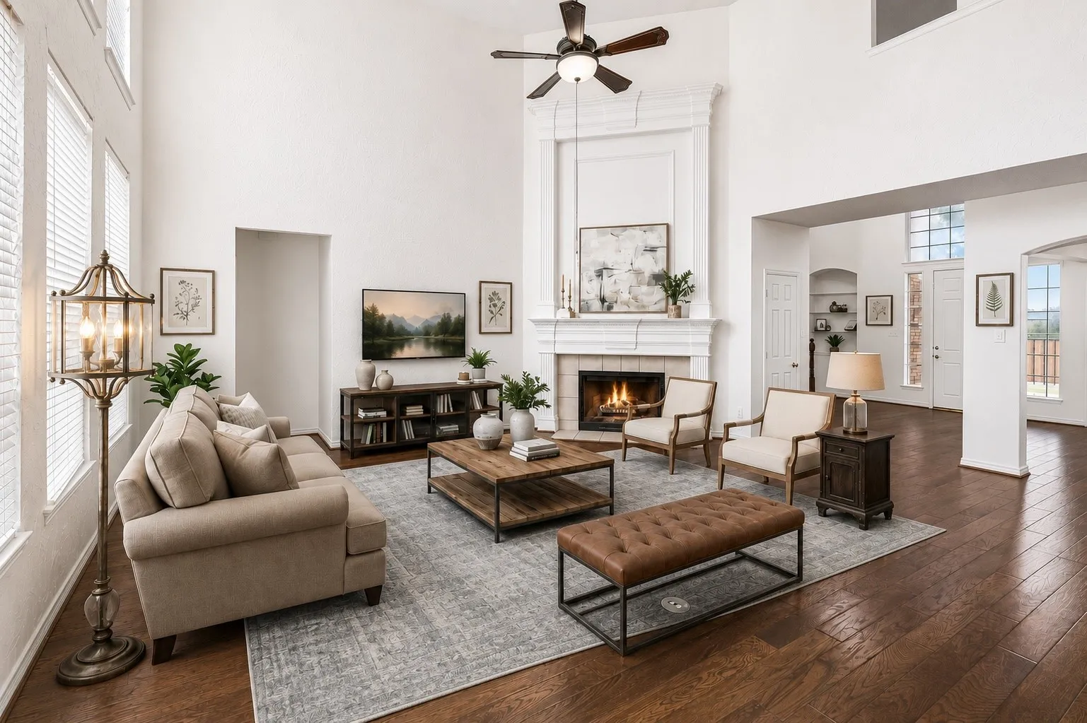 The open-concept family room showcases an impressive fireplace with architectural overmantel and expansive two-story ceilings. *Virtually Staged*