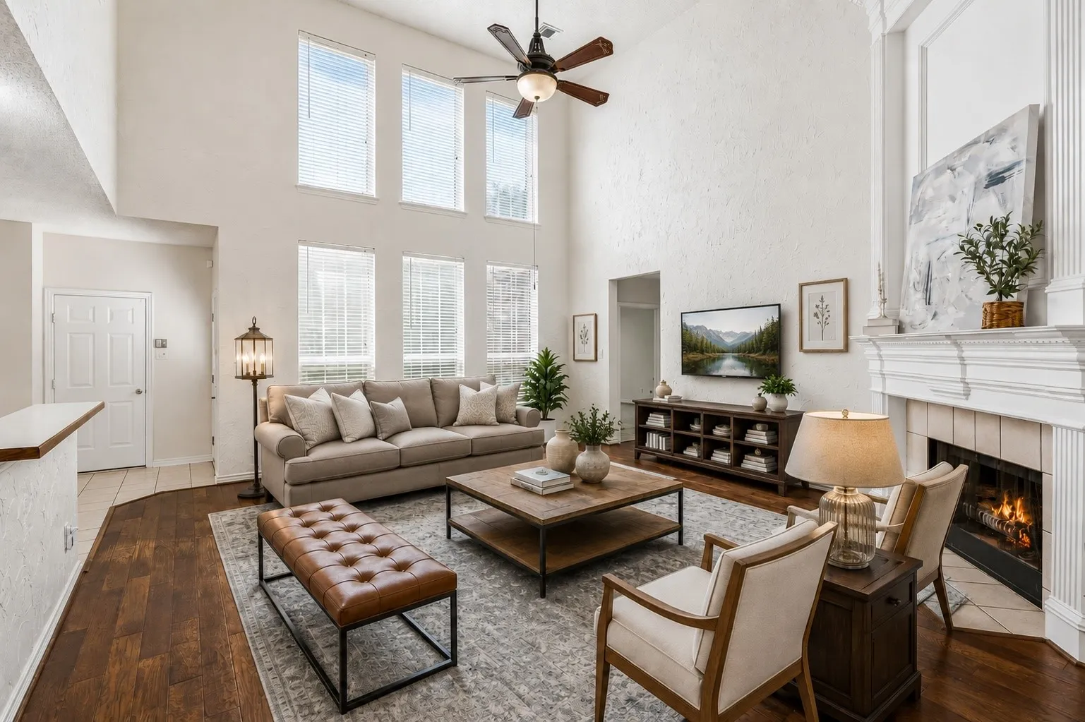 Soaring two-story ceilings and abundant natural light create a dramatic family room at the heart of the home. *Virtually Staged*