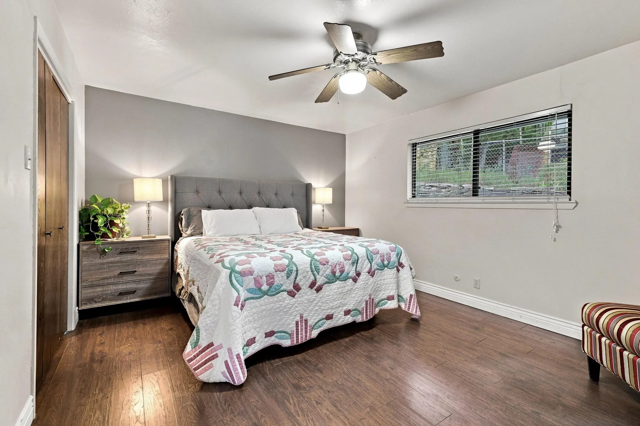 Wood-finish flooring with light-toned wall paint and a ceiling fan