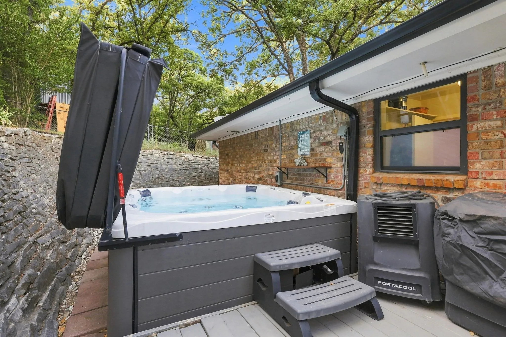 Outdoor hot tub with steps and cover lift