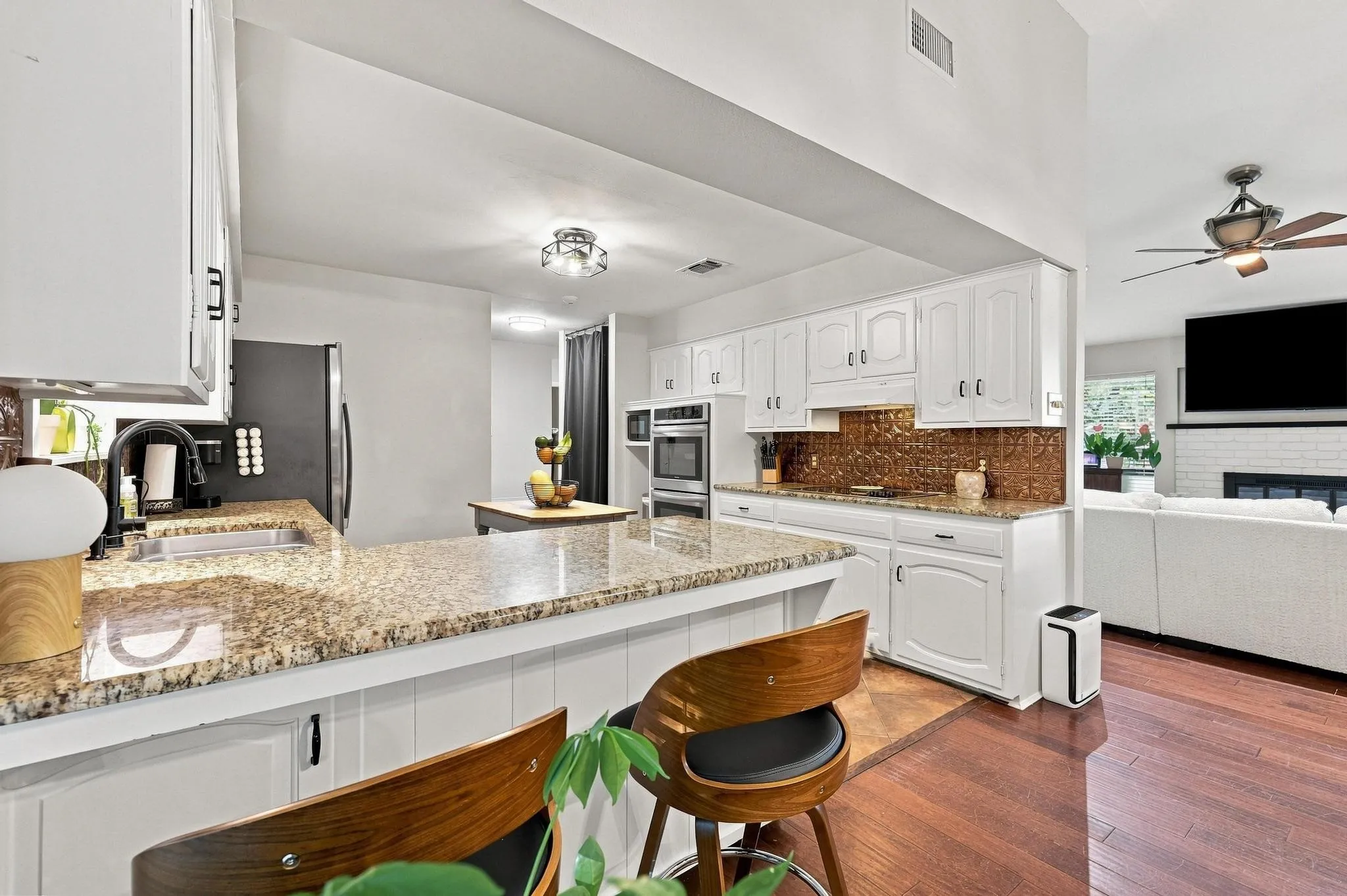 Kitchen with light-colored cabinetry, stone countertops, and a tile backsplash