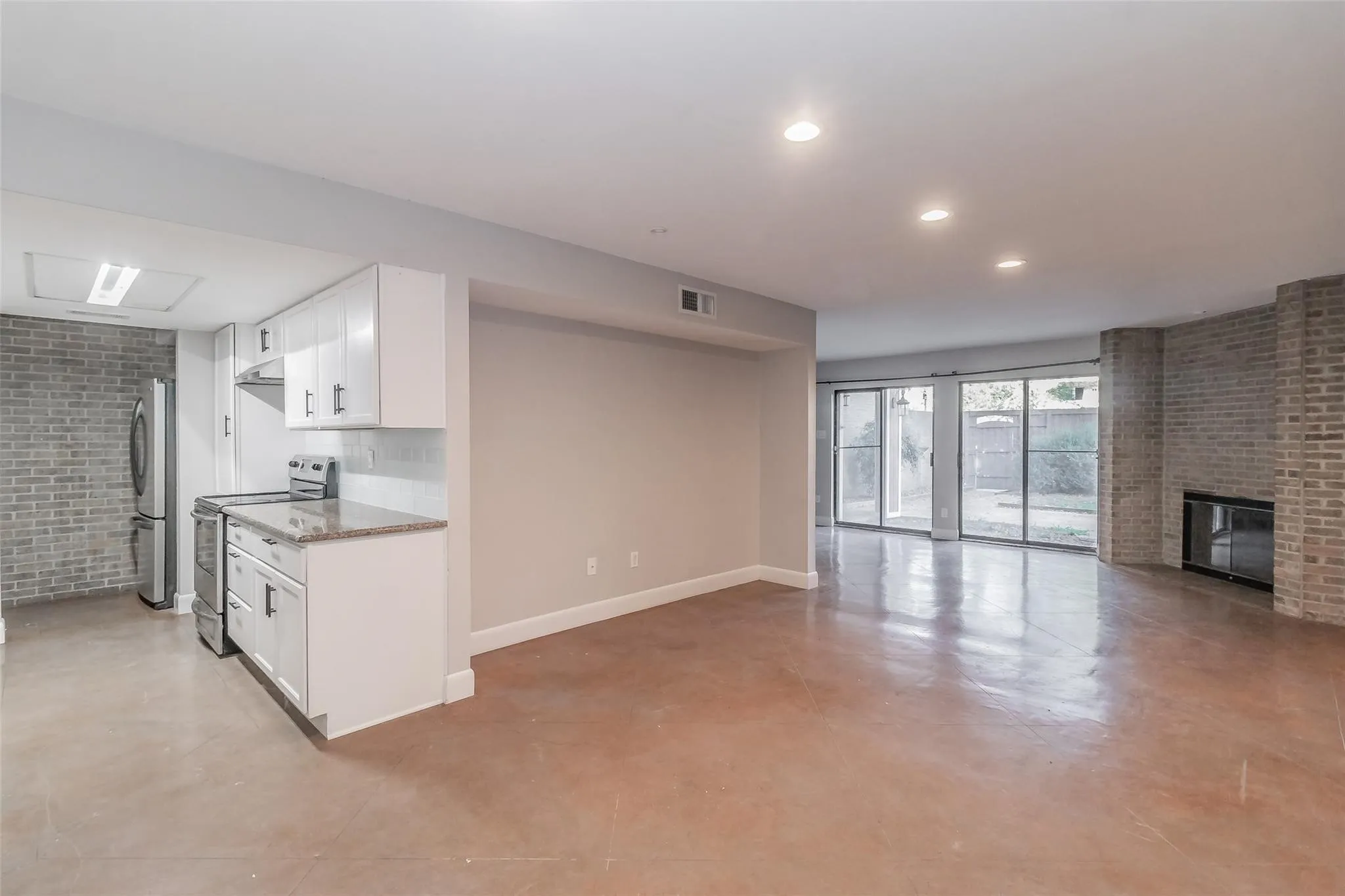 Kitchen with white cabinetry, stainless steel appliances, and stone countertops