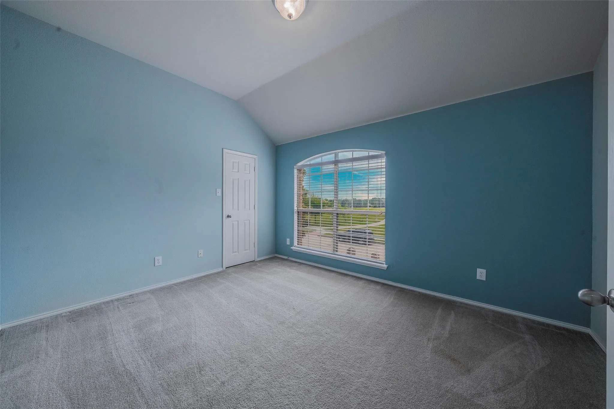 Carpeted spare room with lofted ceiling