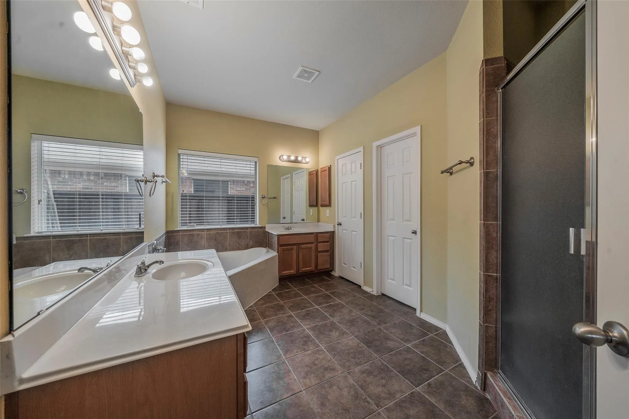 Bathroom featuring tile patterned floors, vanity, and plus walk in shower
