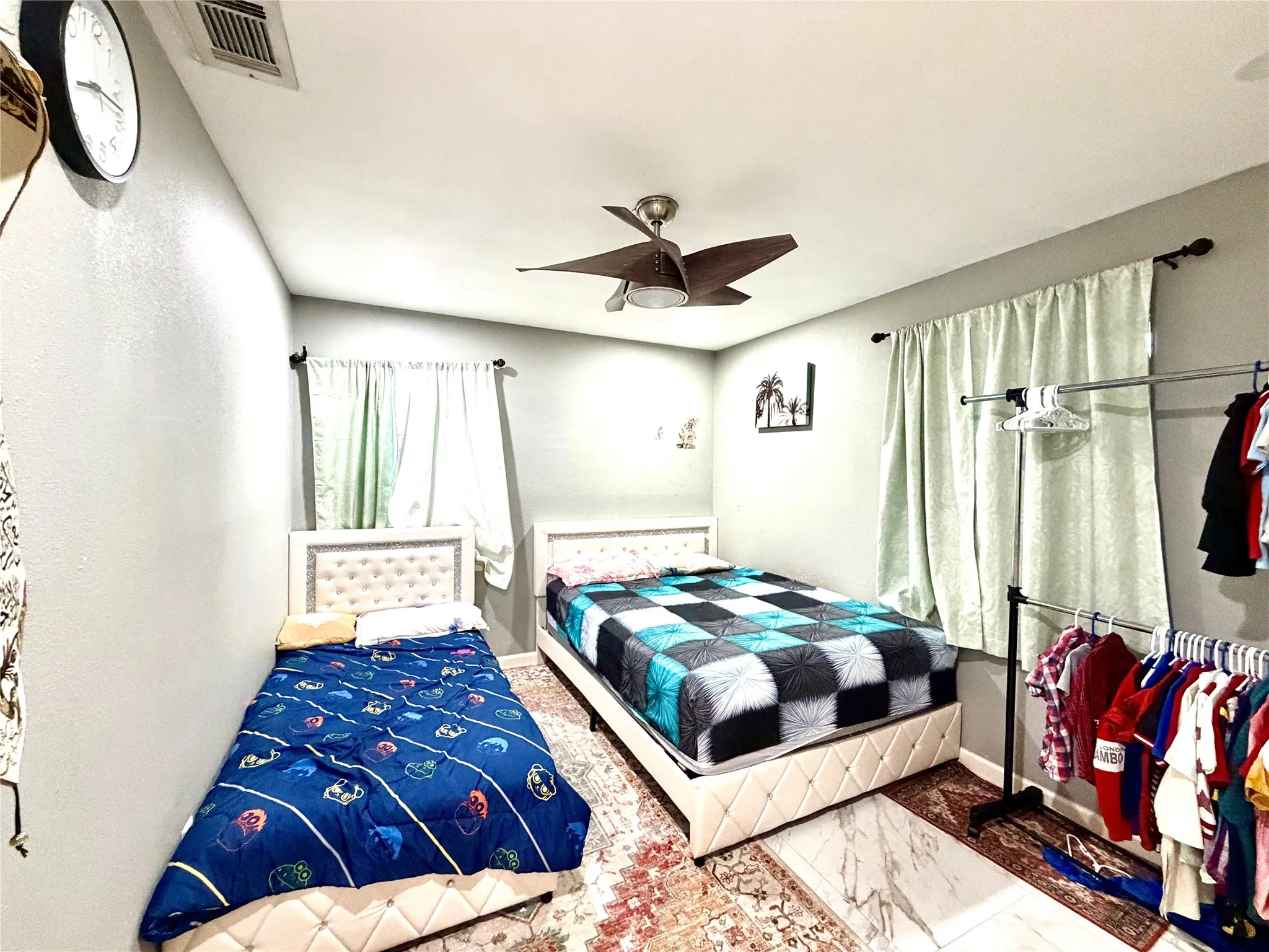 Interior room featuring light gray walls, a textured ceiling, and wood-finish flooring partially covered by an area rug