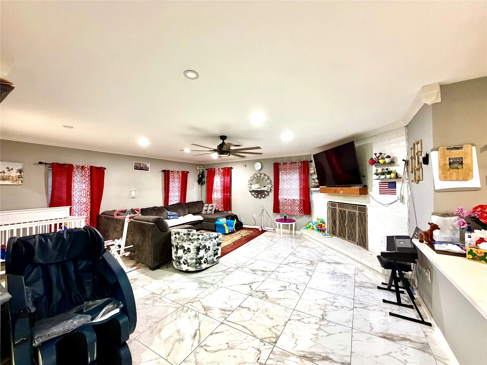 Spacious living area featuring large format marble-look tile flooring and recessed lighting