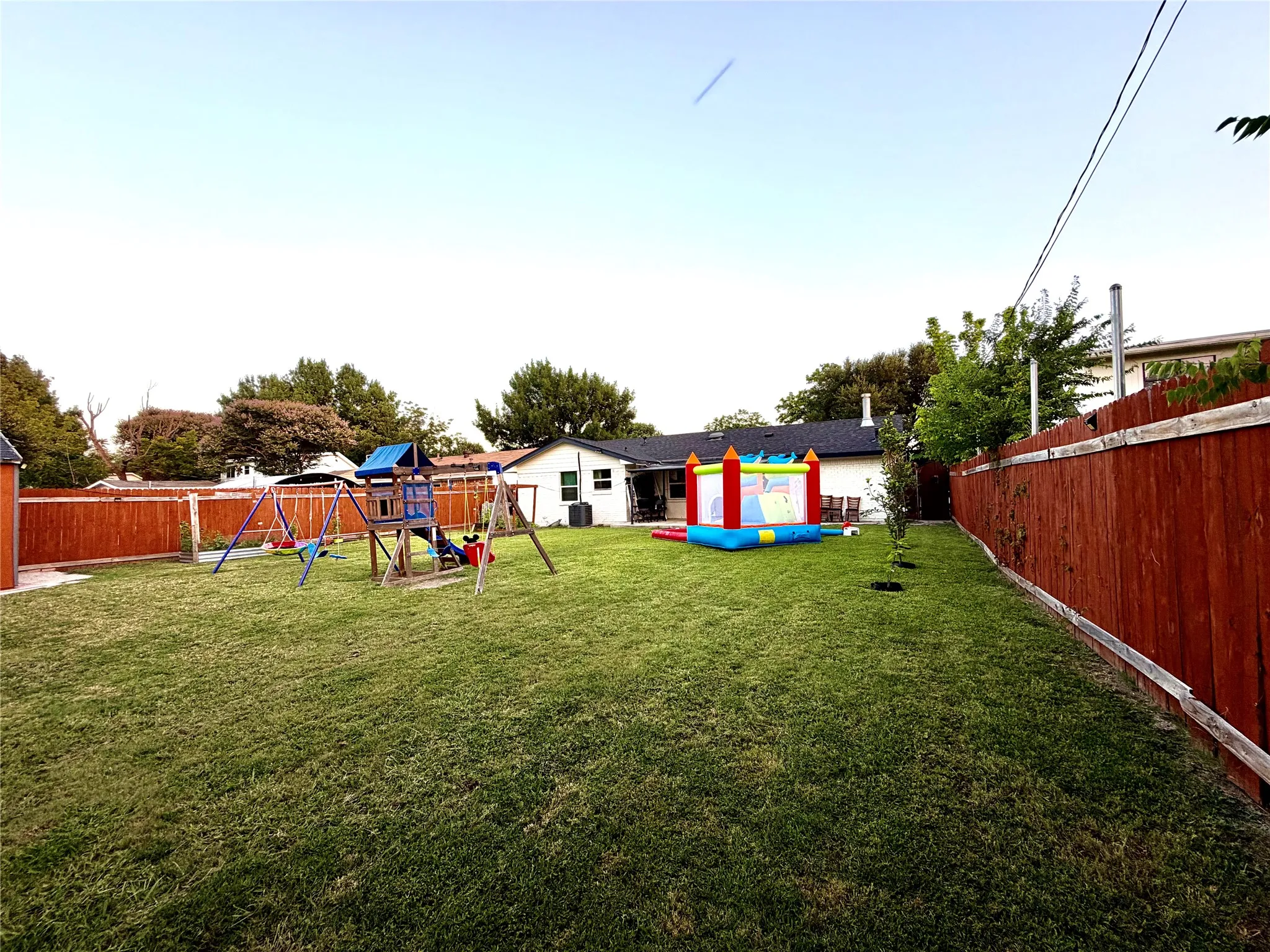 Expansive green lawn with a privacy fence enclosing the perimeter