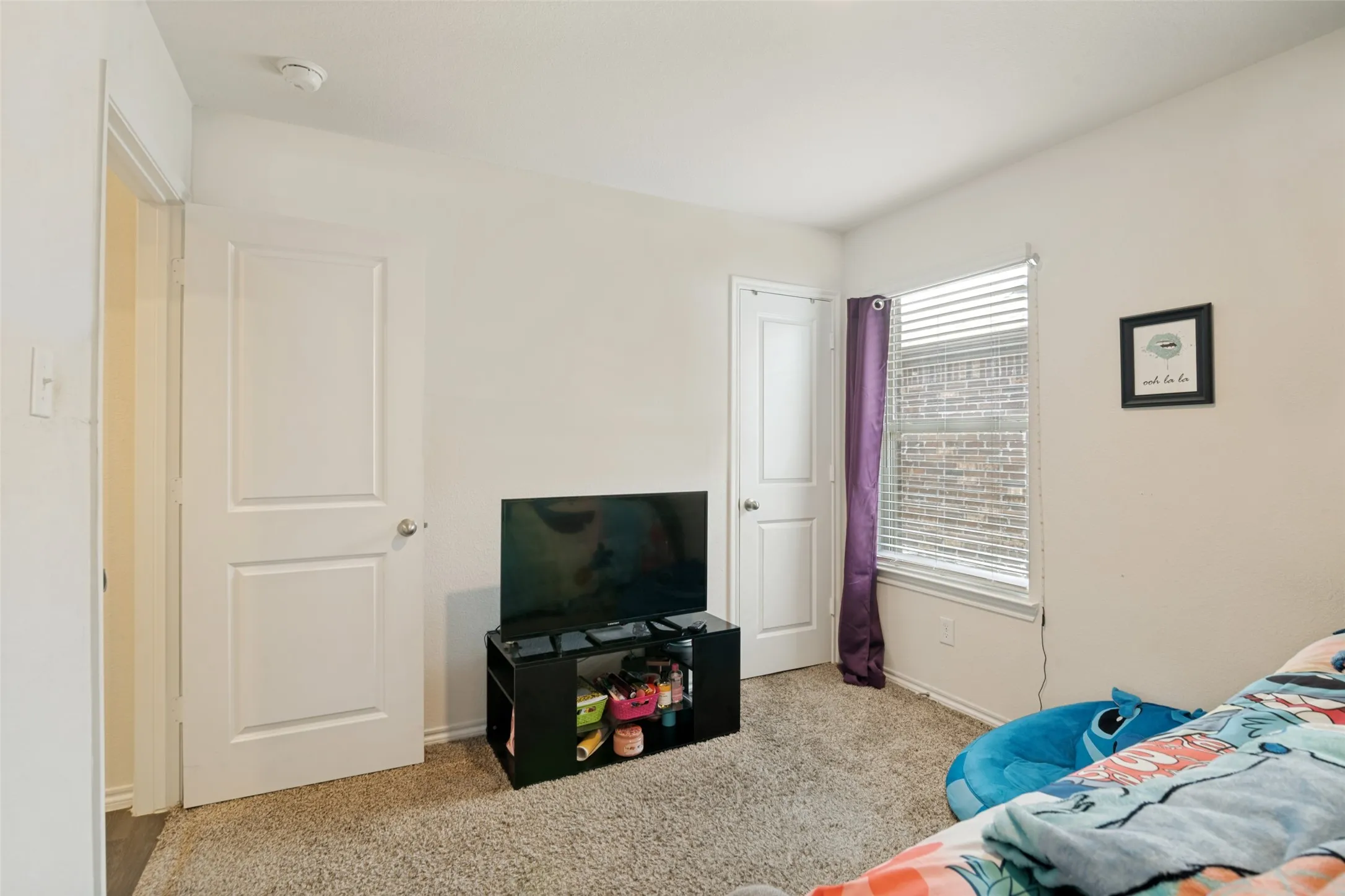 Carpeted flooring, white walls, white interior doors, and a window with blinds