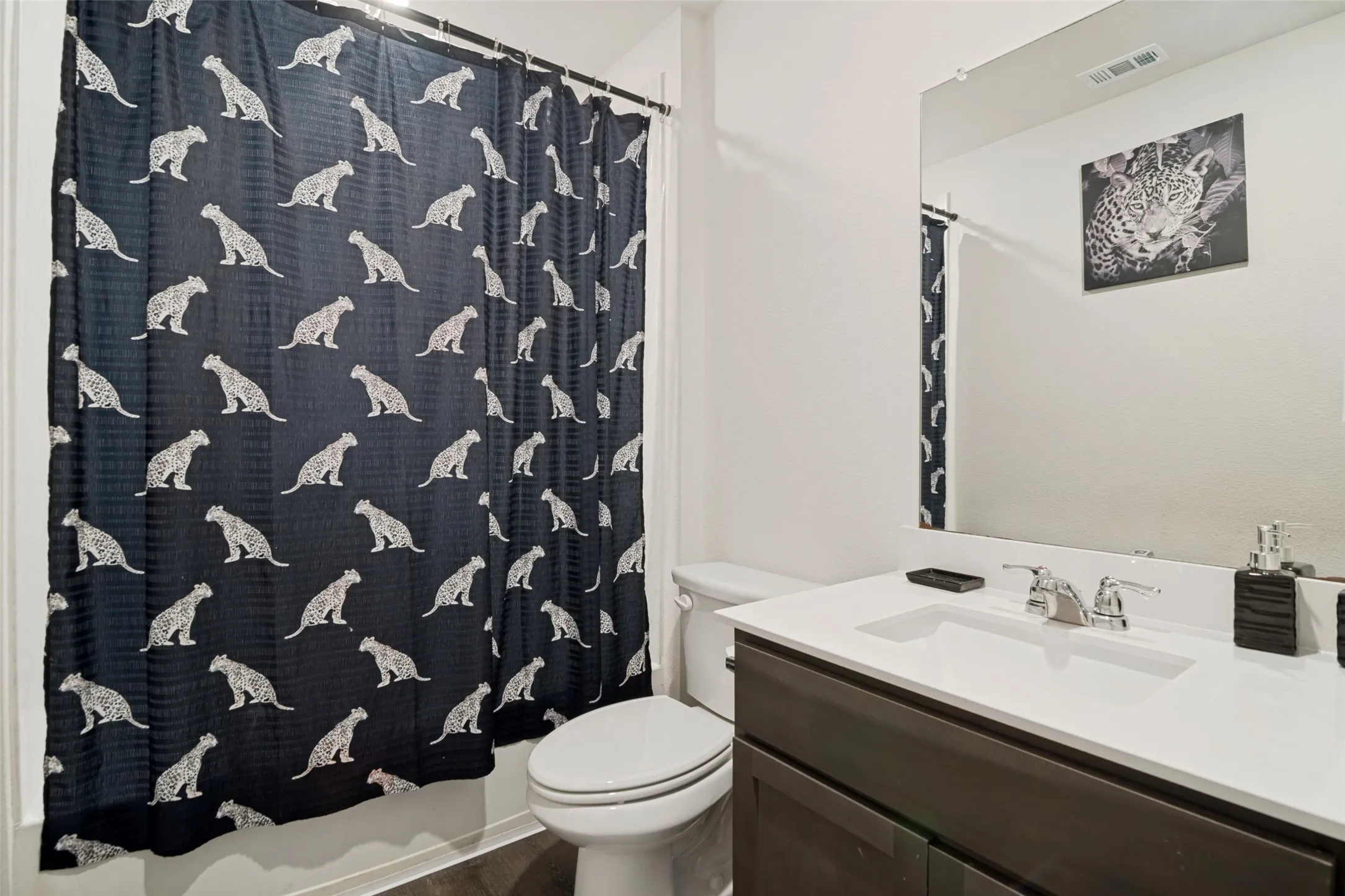 Integrated vanity with a single basin sink, chrome faucet, and dark wood-finish cabinetry