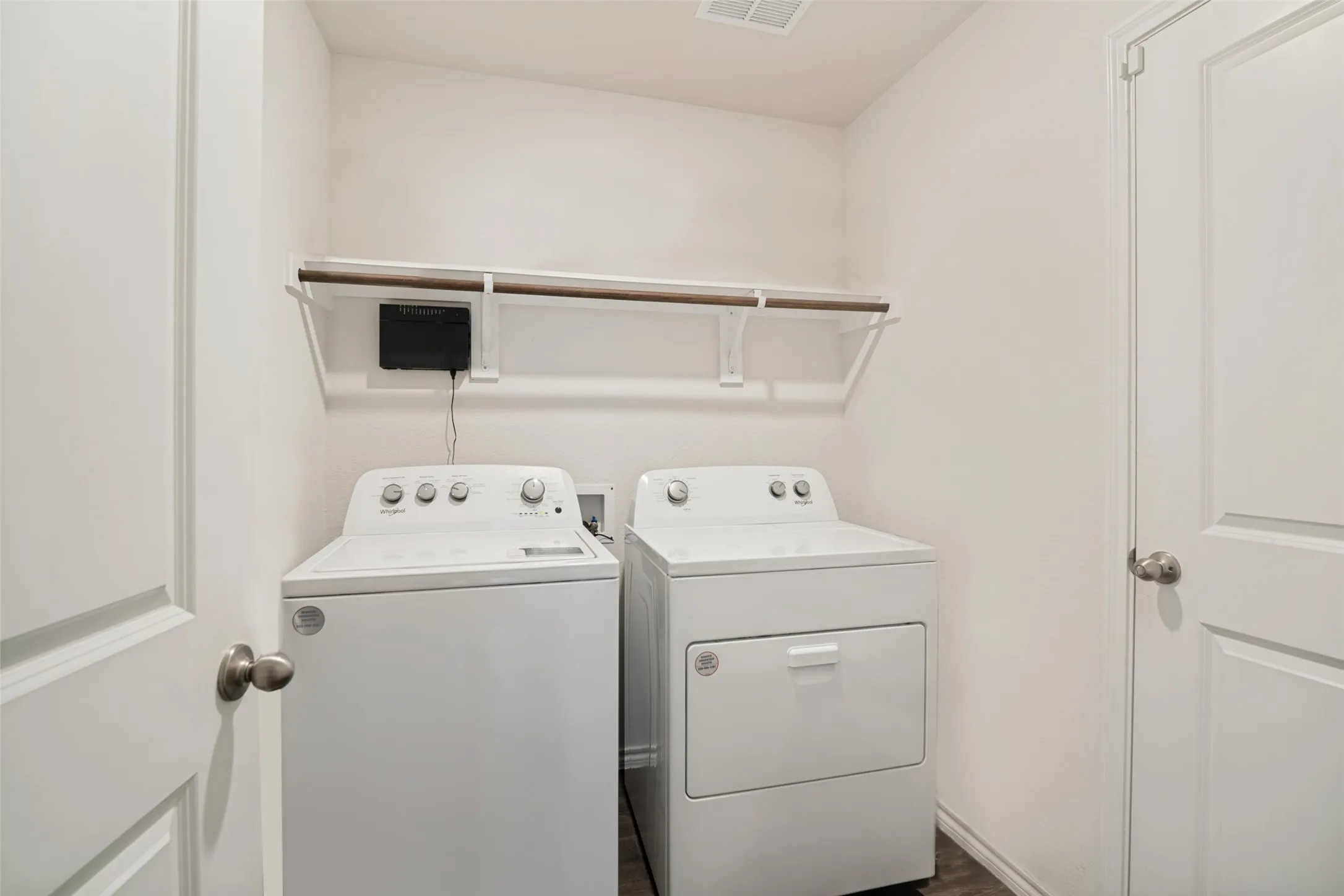 Built-in overhead shelving with hanging rod, durable white doors, and brushed nickel hardware