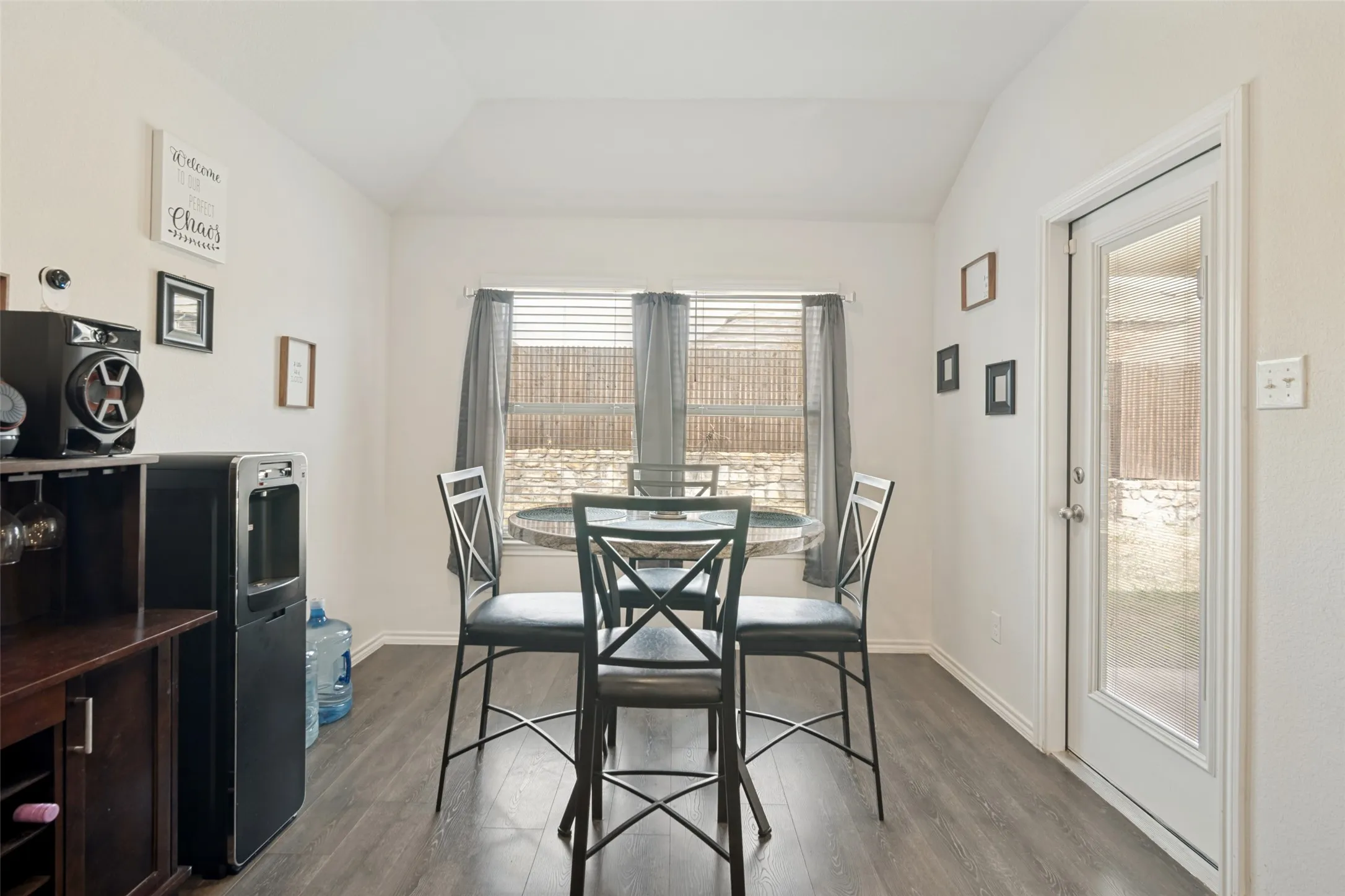 Wood-finish flooring throughout, vaulted ceiling, and an exterior door with glass insert