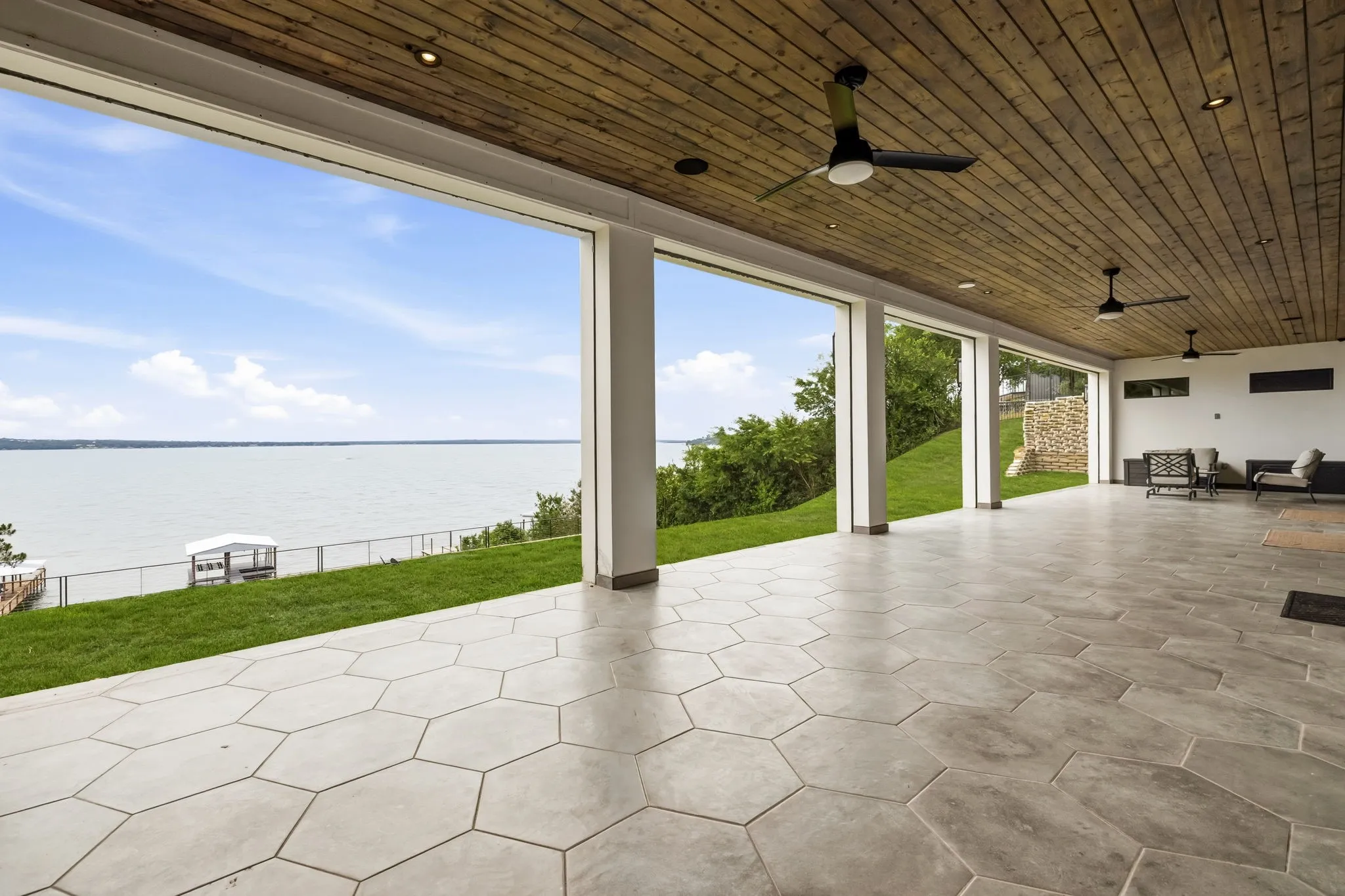 Expansive patio with hexagonal paver flooring and a wood-panel ceiling