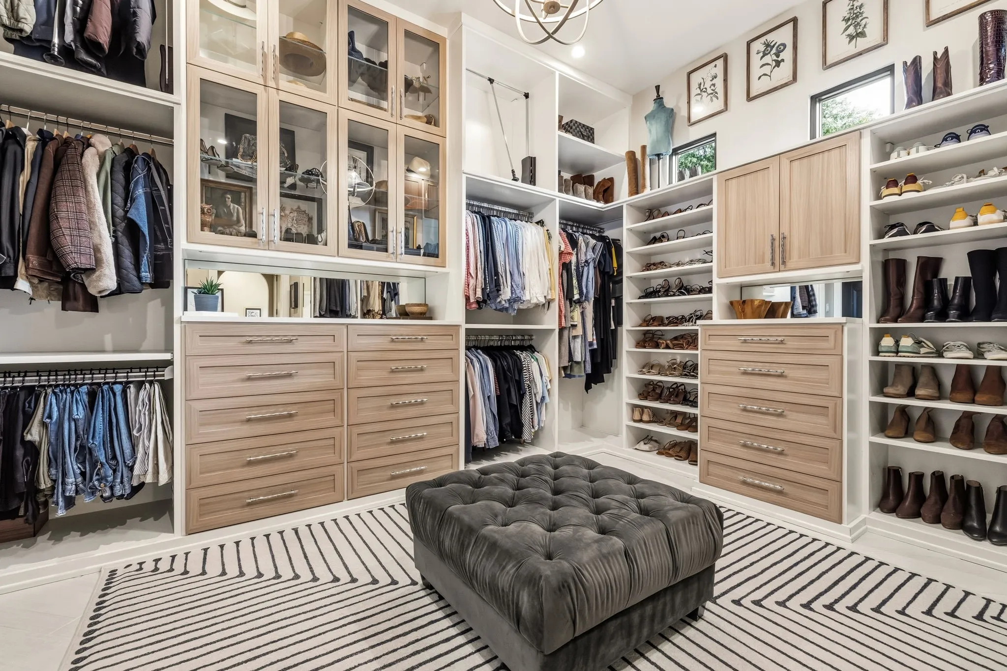 Custom closet system featuring built-in drawers, glass-front cabinetry, and extensive shelving
