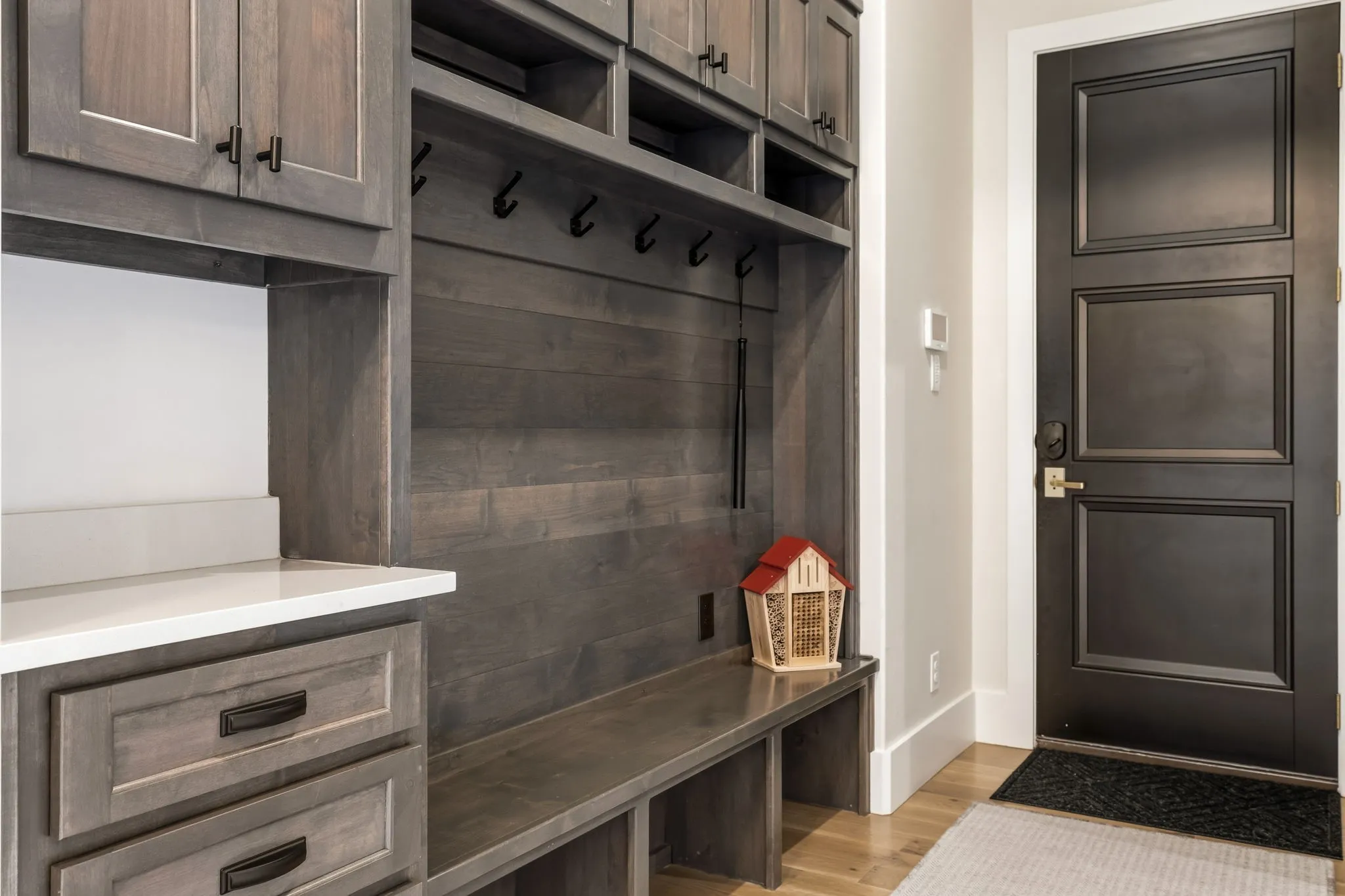 Built-in mudroom cabinetry with wood-finish construction, integrated bench seating, and upper storage compartments