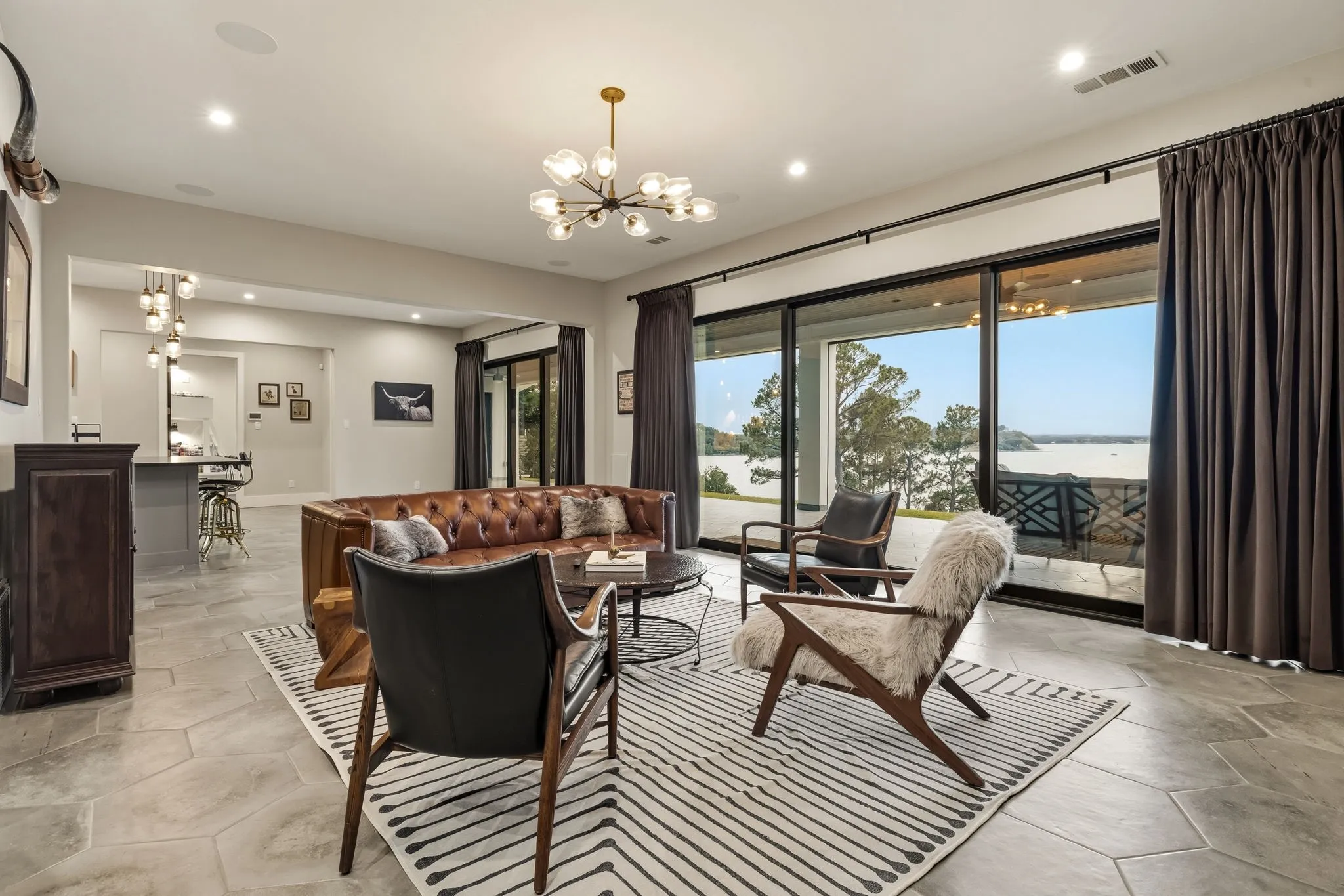 Spacious living area featuring large-format hexagonal tile flooring and recessed lighting