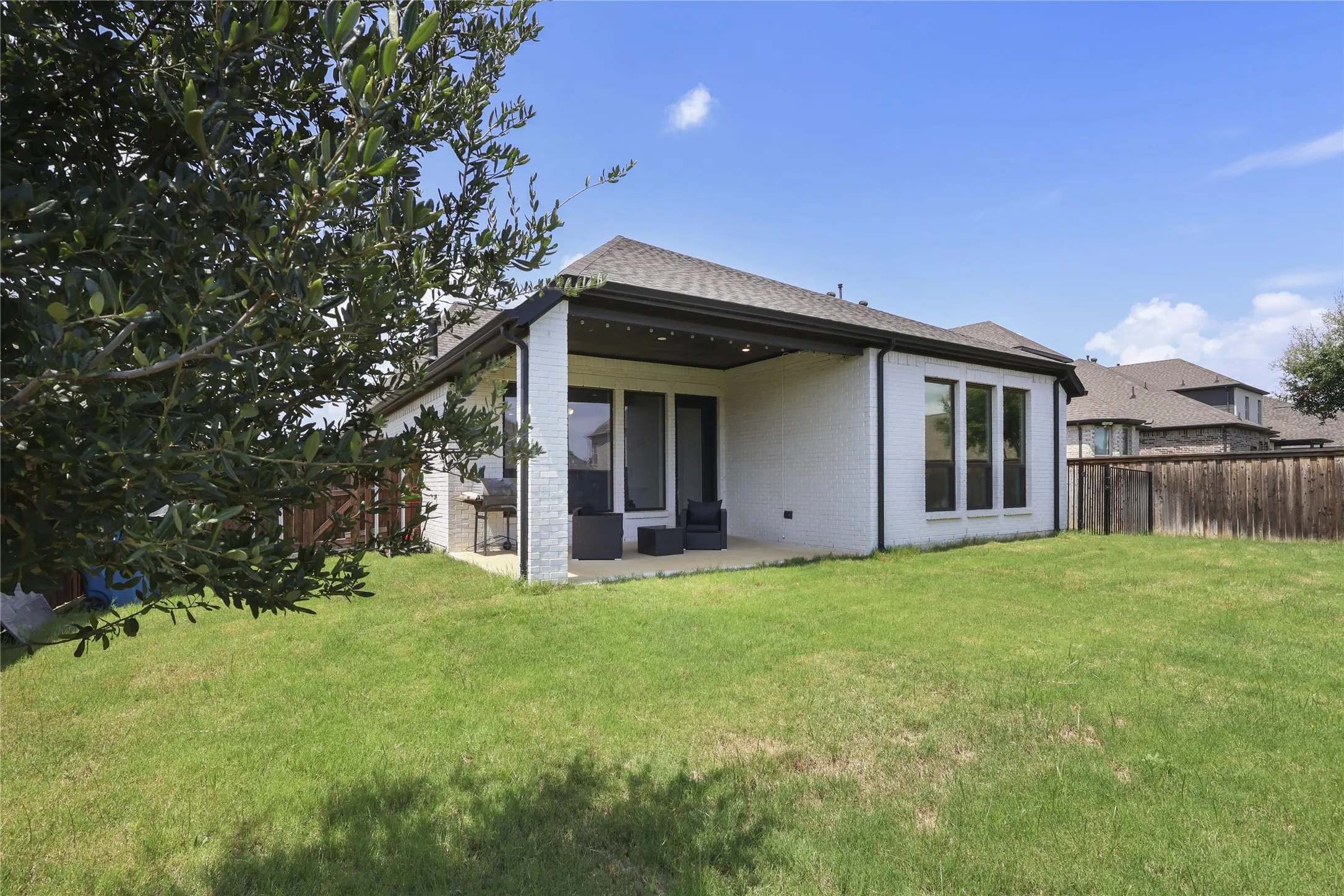 Expansive grassy backyard featuring a full privacy fence