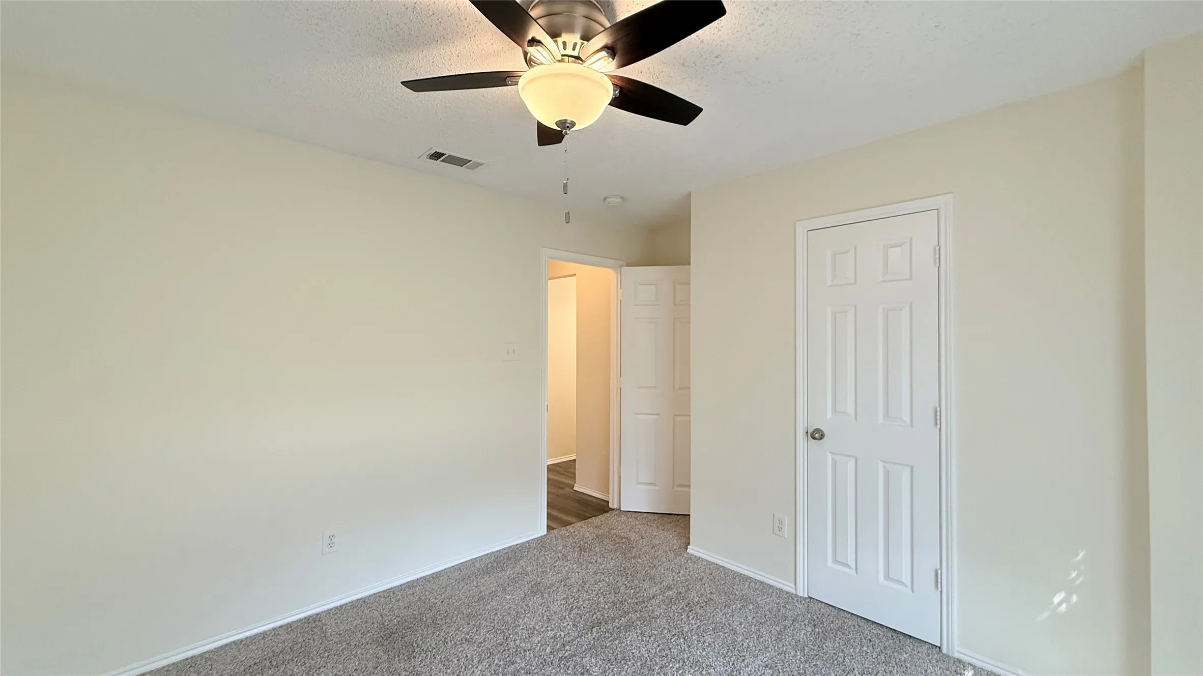 Plush carpet flooring, ceiling fan with integrated lighting, paneled interior doors, and neutral wall tones