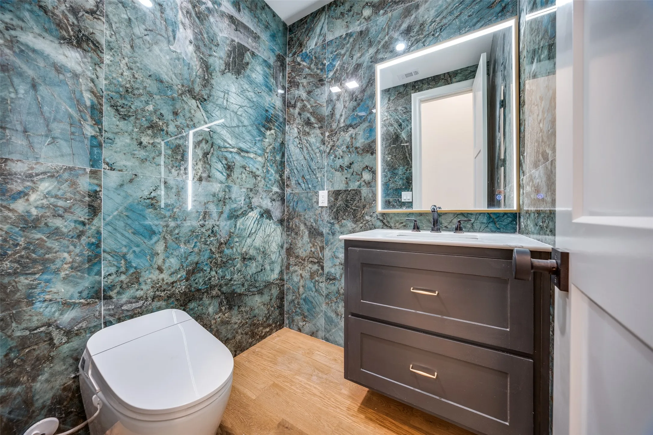 Floating vanity with a white countertop and rectangular sink, accented by a black faucet