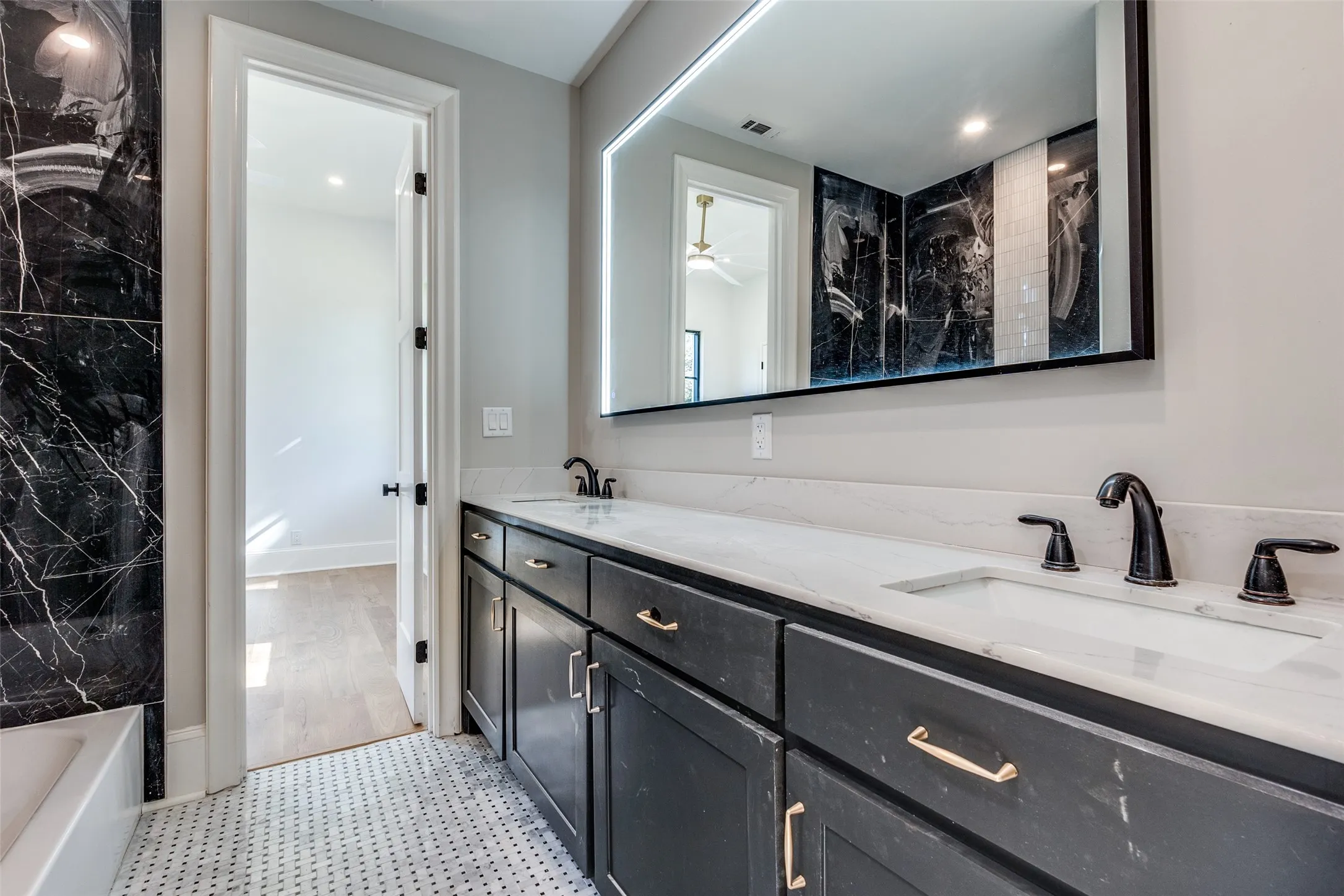 Dual vanity with undermount sinks, matte black fixtures, and light-colored countertops